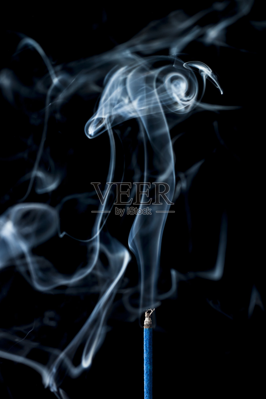 黑色背景上熏香的烟雾照片摄影图片