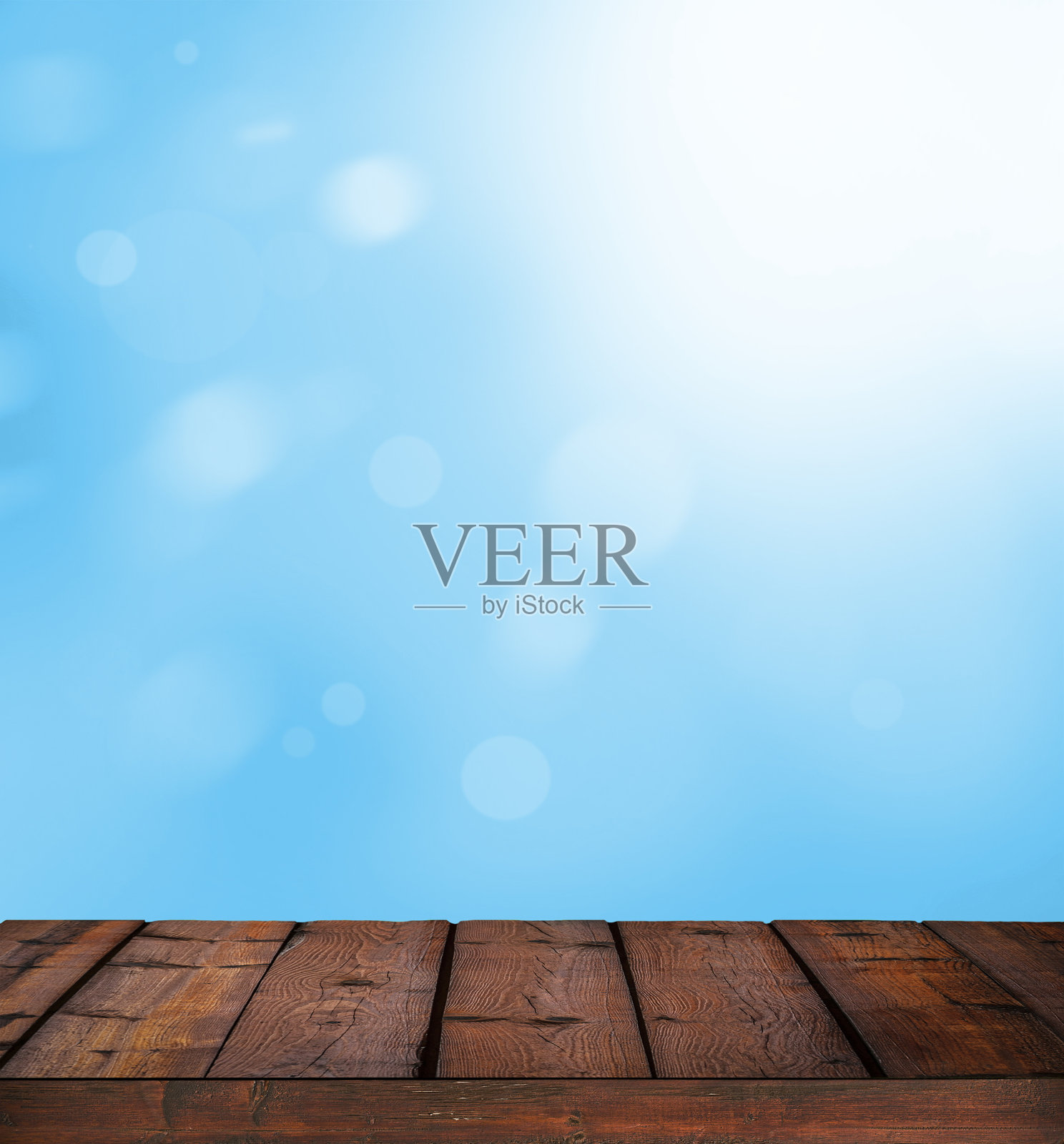 蓝色明亮的散景和阳光映衬着木地板照片摄影图片