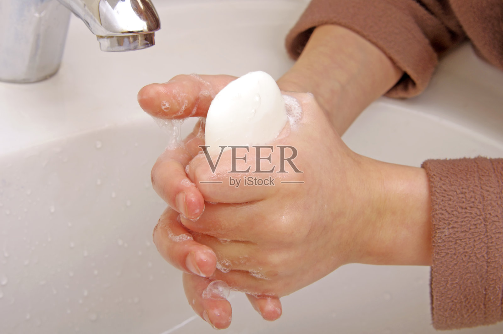 妇女用流动的水和肥皂洗手照片摄影图片