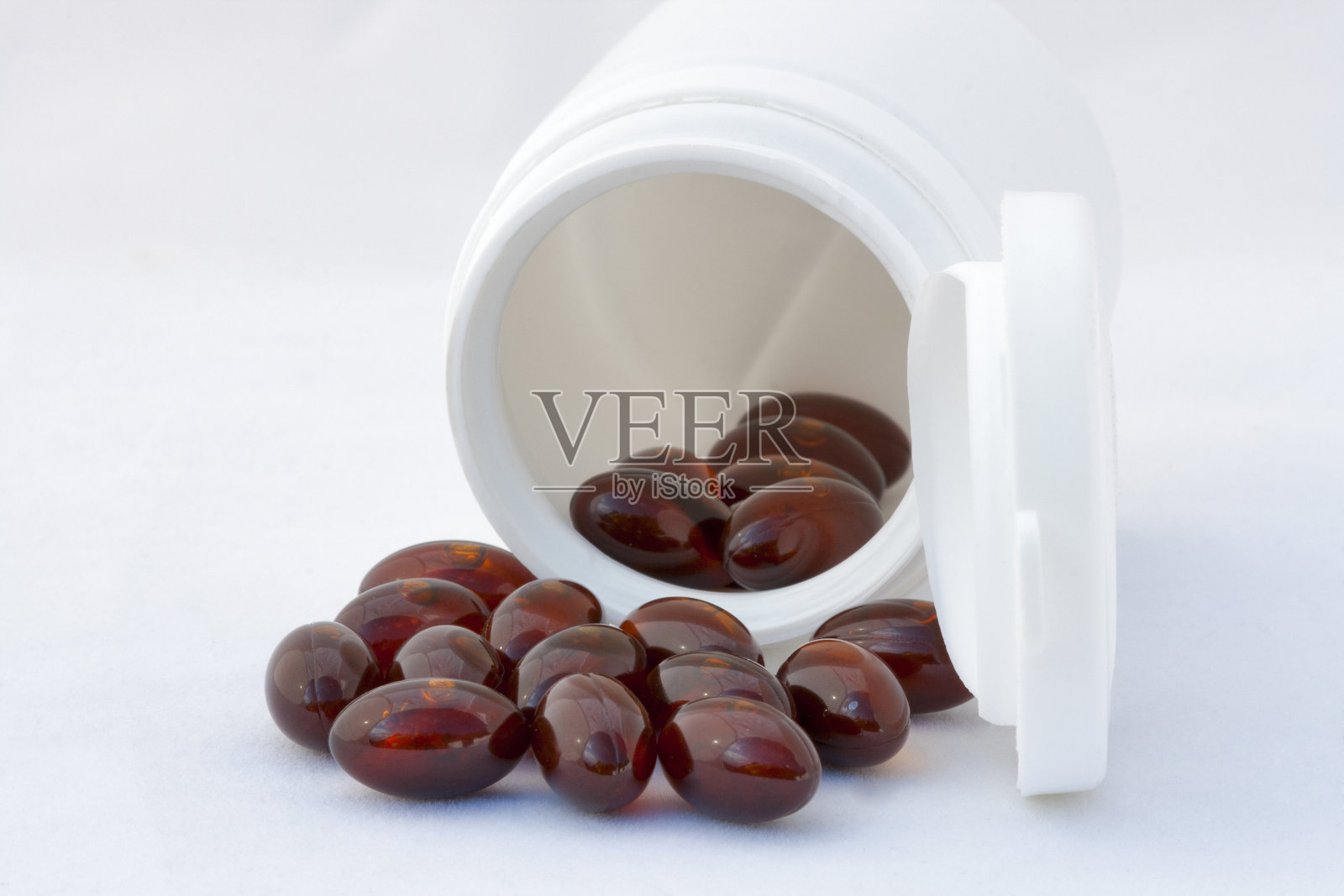 倒装瓶，棕色胶囊对白色照片摄影图片