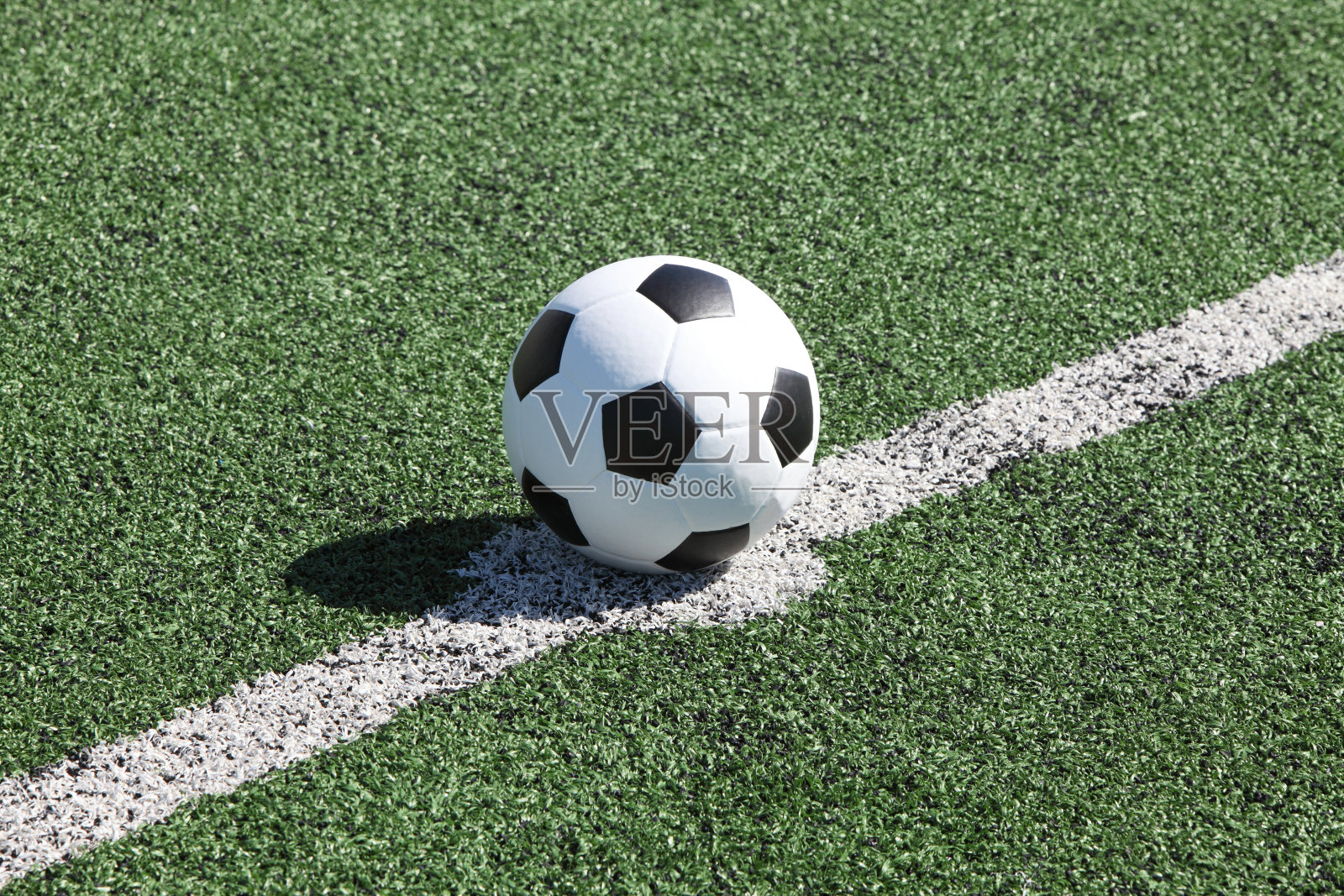 足球在绿草的白线上照片摄影图片