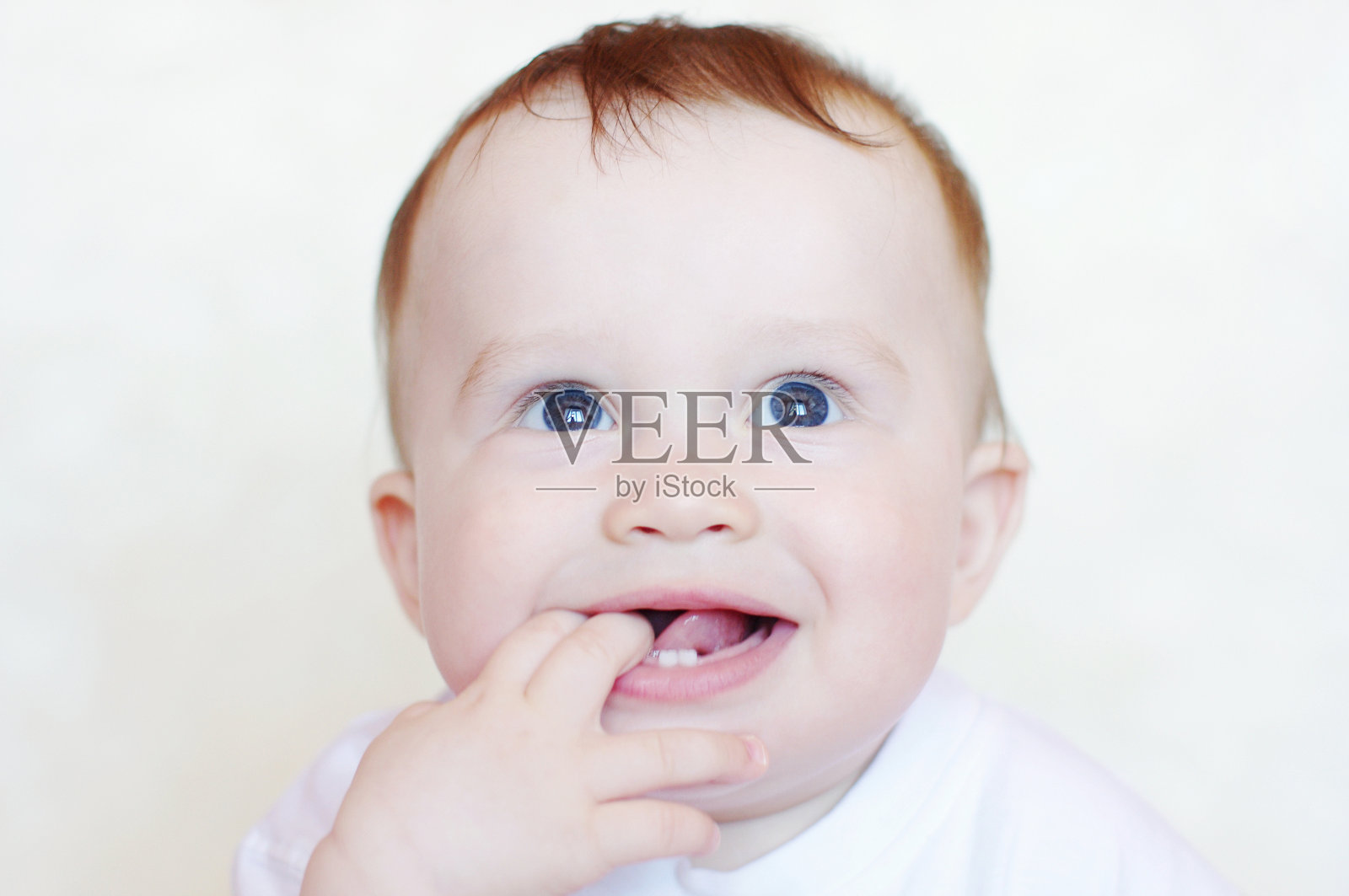 可爱的婴儿，手指在嘴里照片摄影图片