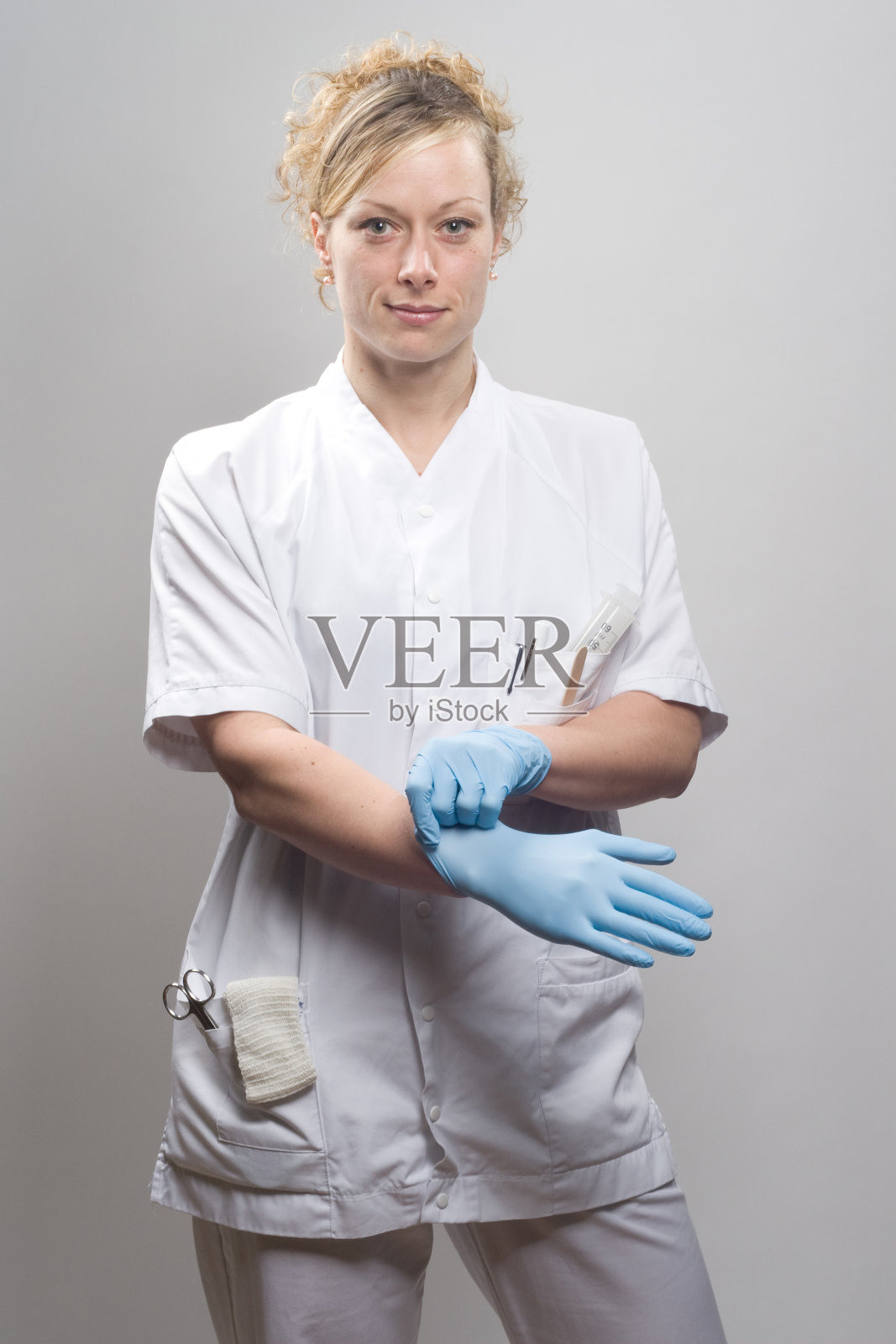 护士将右手放入防护手套照片摄影图片