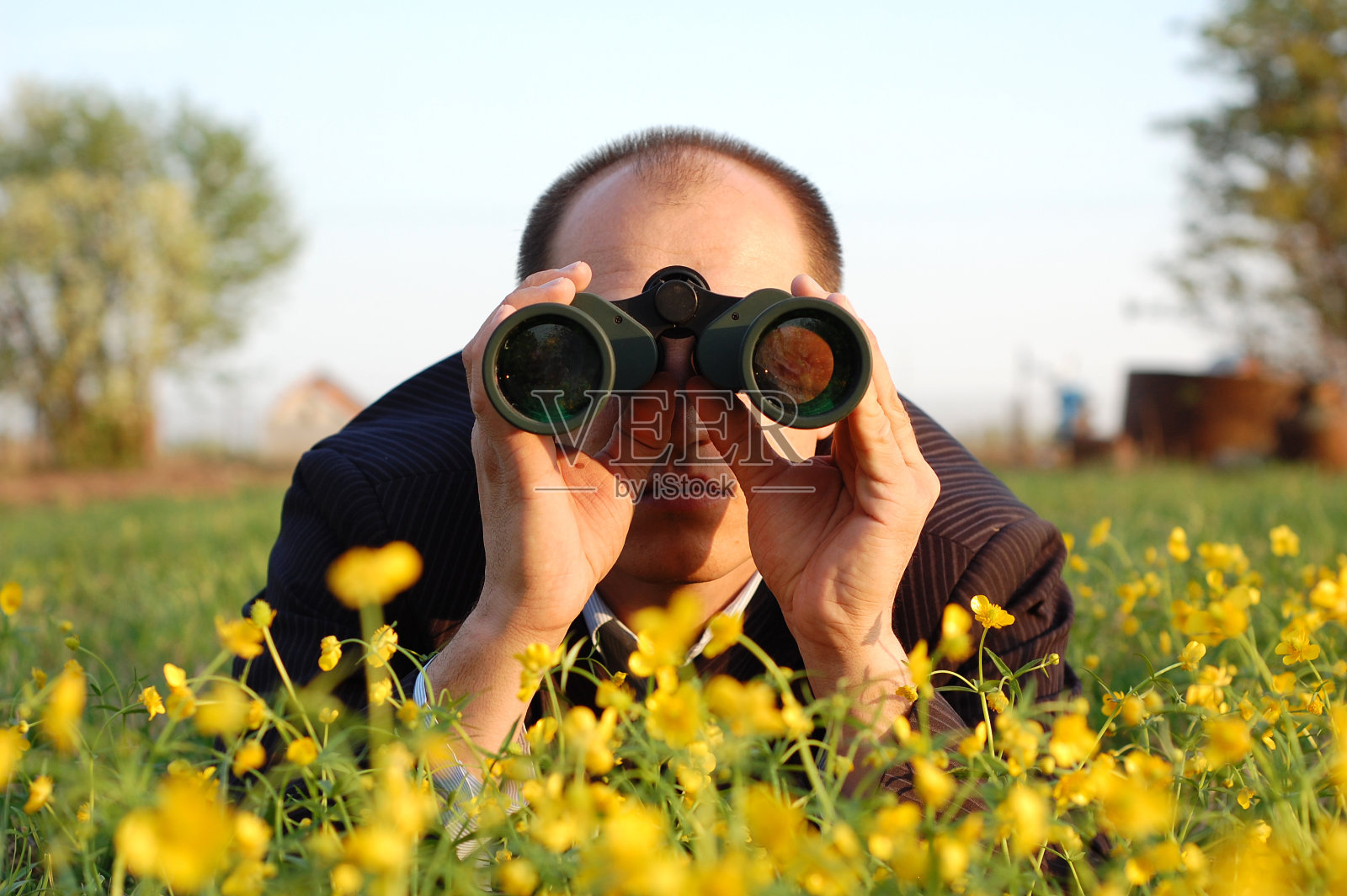 男人躺在花上，用望远镜看照片摄影图片