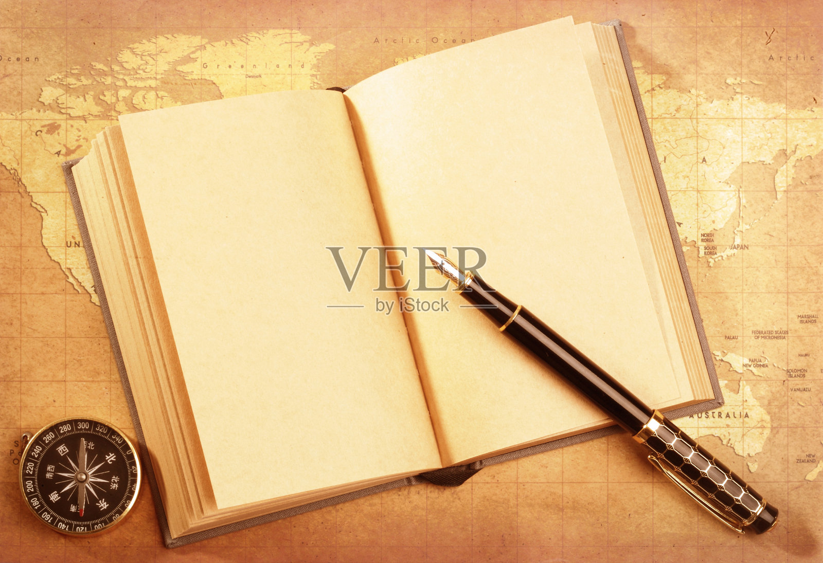 笔和书，指南针在地图上照片摄影图片