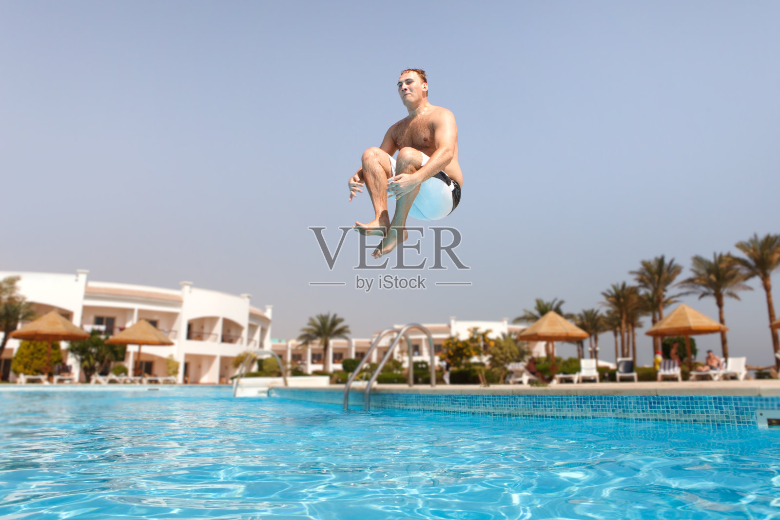 在游泳池里跳的男人照片摄影图片