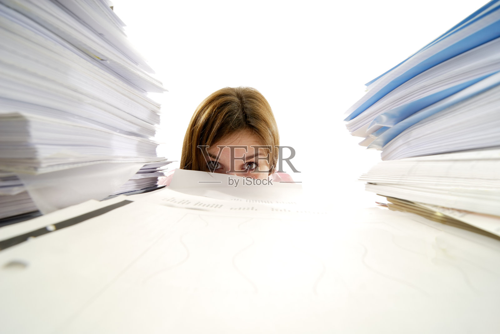 年轻女子从一堆文件后面看过去照片摄影图片