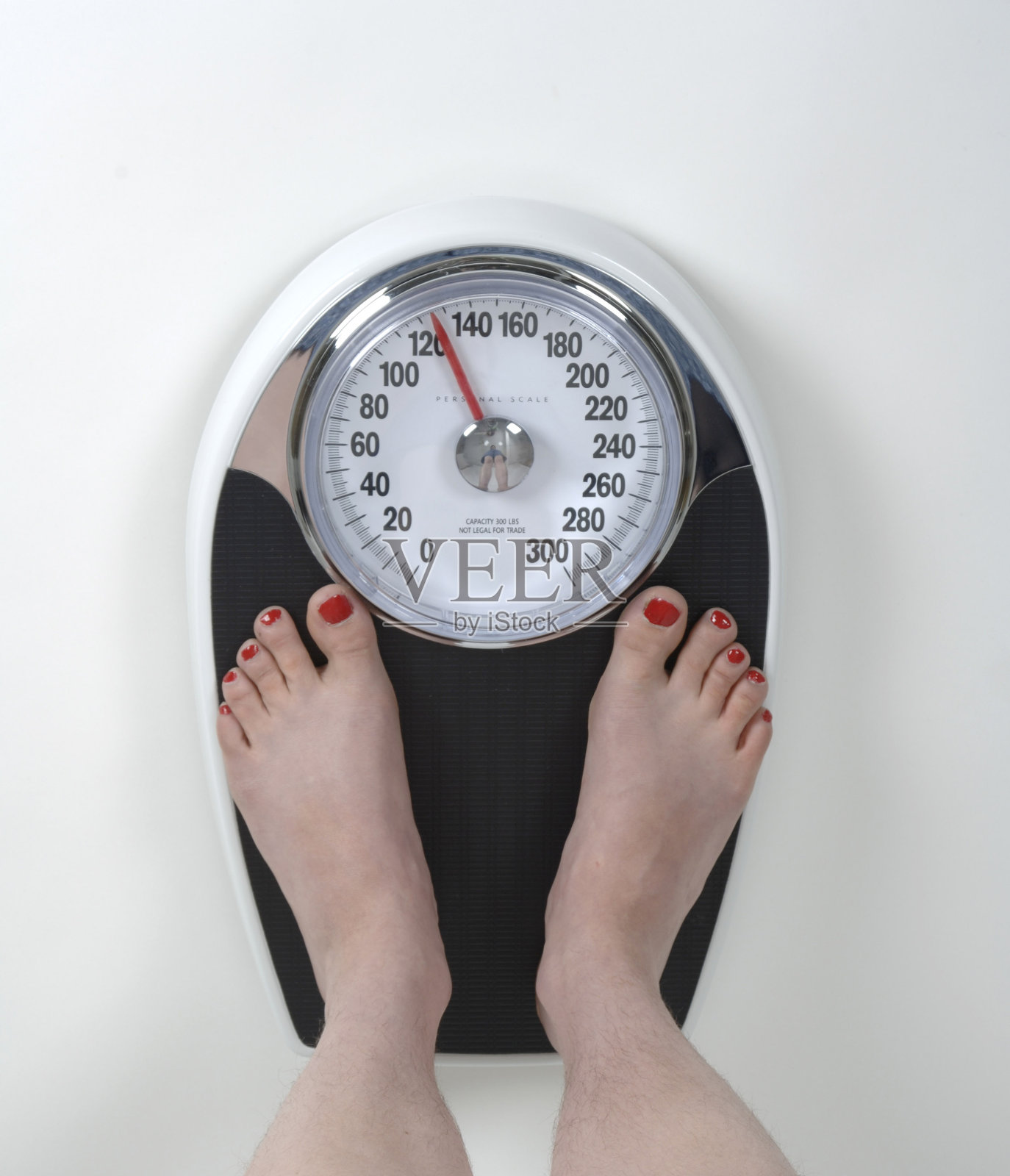 一个女人在浴室的秤上称自己的体重照片摄影图片