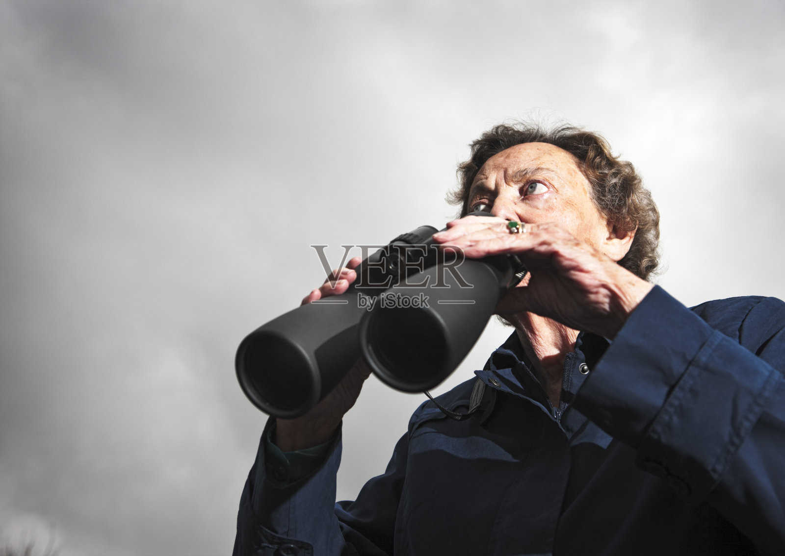 焦虑的老年人拿着双筒望远镜照片摄影图片