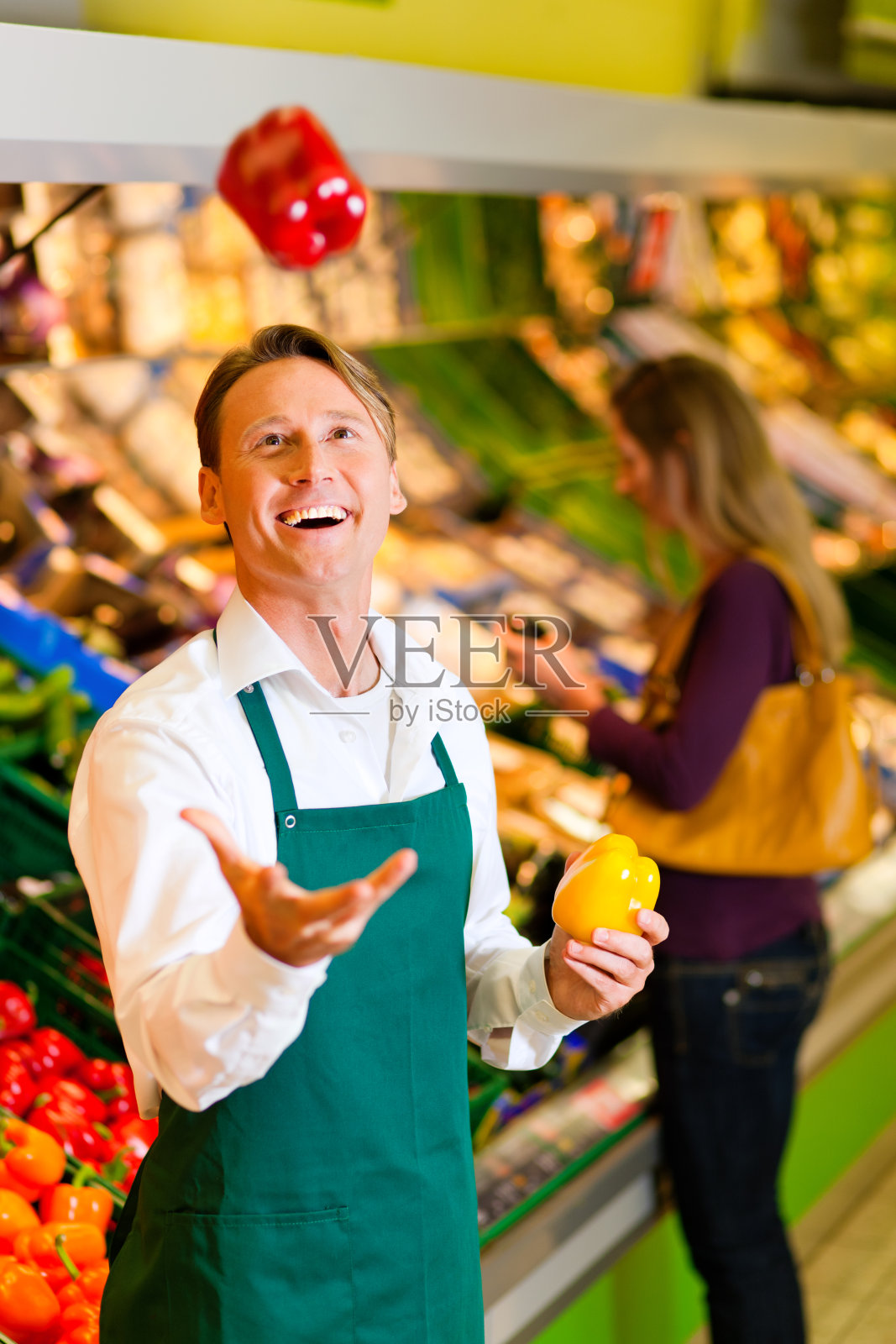 一个超市员工在向空中扔蔬菜照片摄影图片