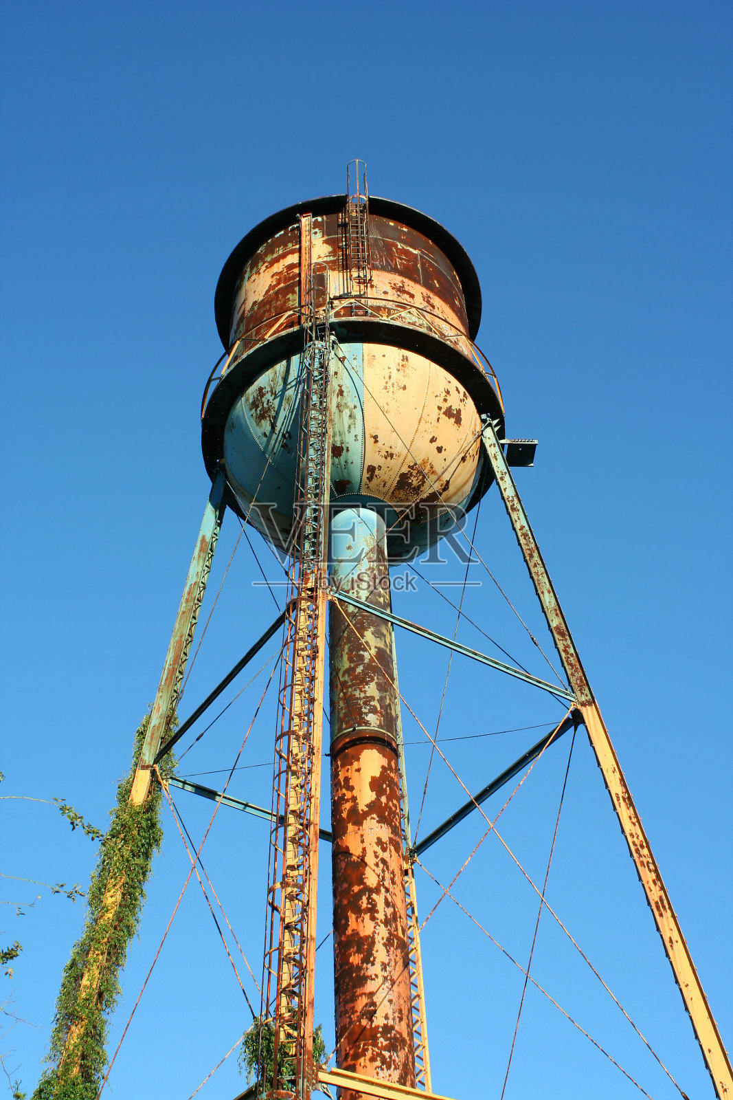 蓝色天空映衬着生锈的水塔照片摄影图片