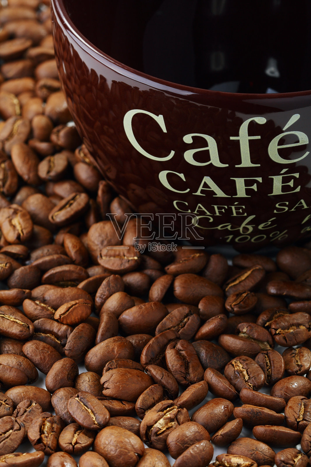 陶瓷杯上的咖啡豆。照片摄影图片