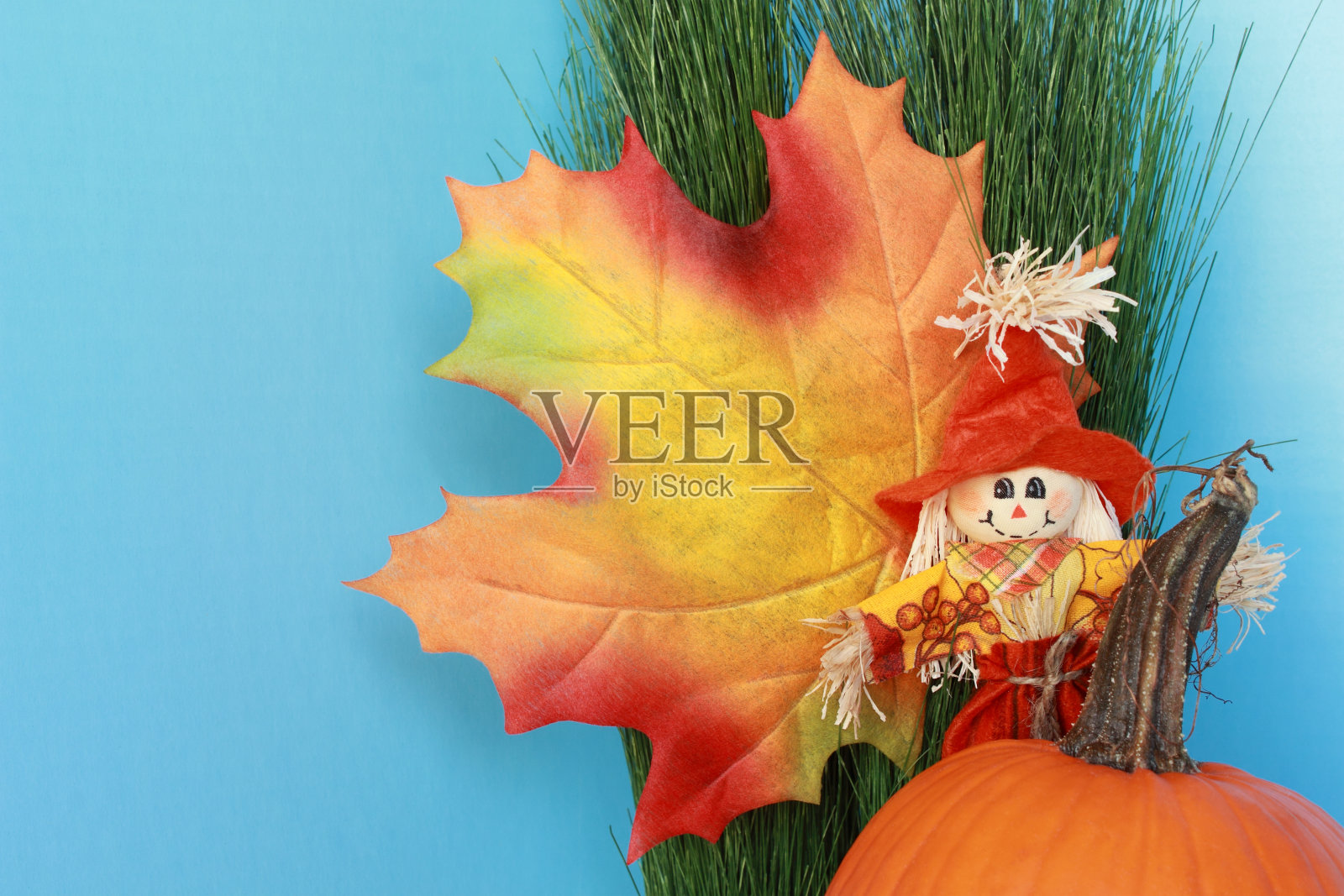 秋天有树叶、稻草人和南瓜的静物照片摄影图片