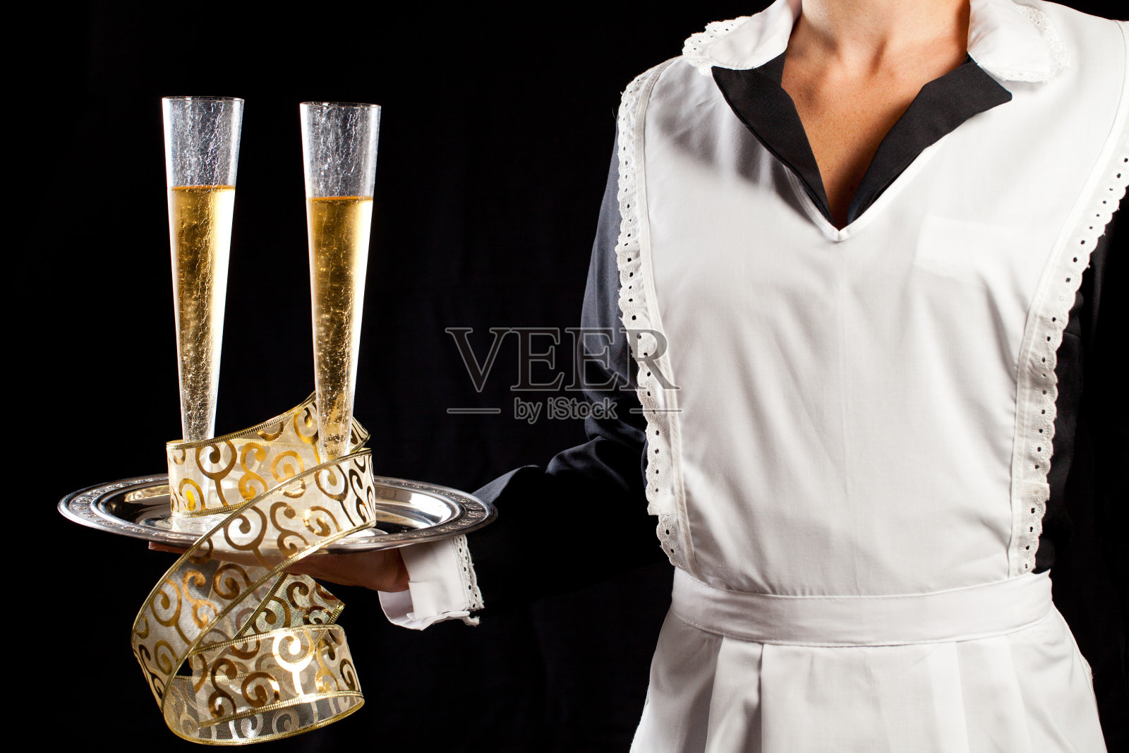 年轻的女保洁员端着香槟照片摄影图片