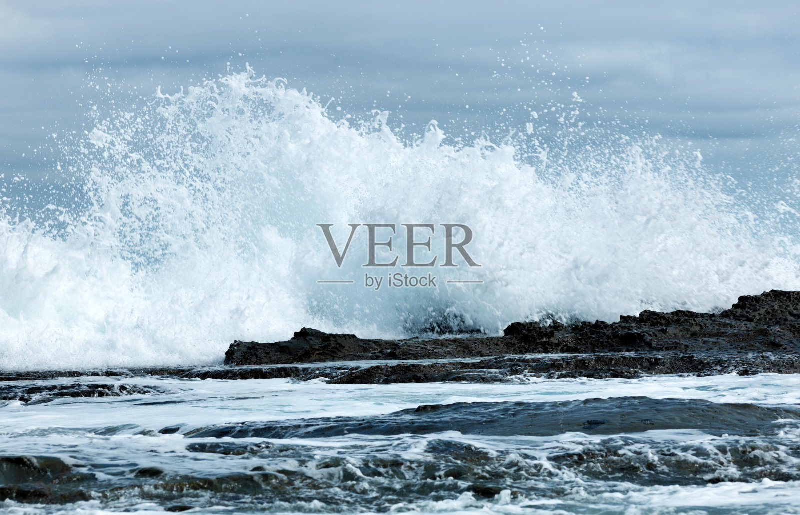 水溅在海洋岩石上照片摄影图片