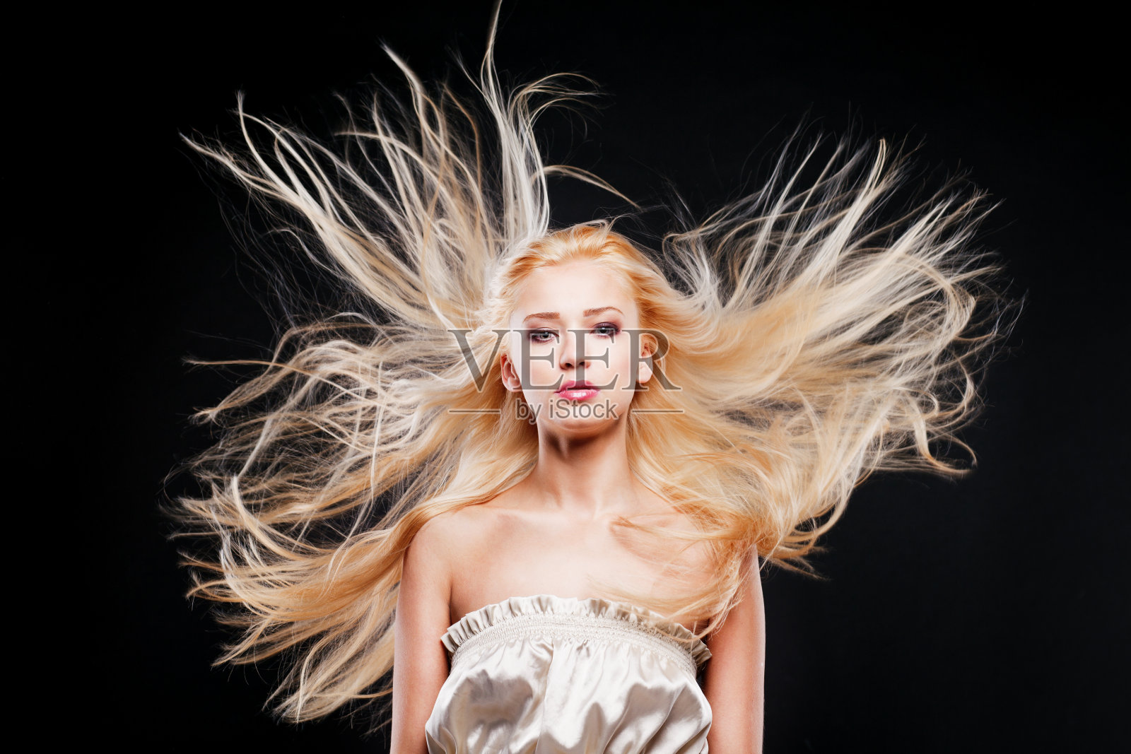 年轻的金发美女在风中照片摄影图片