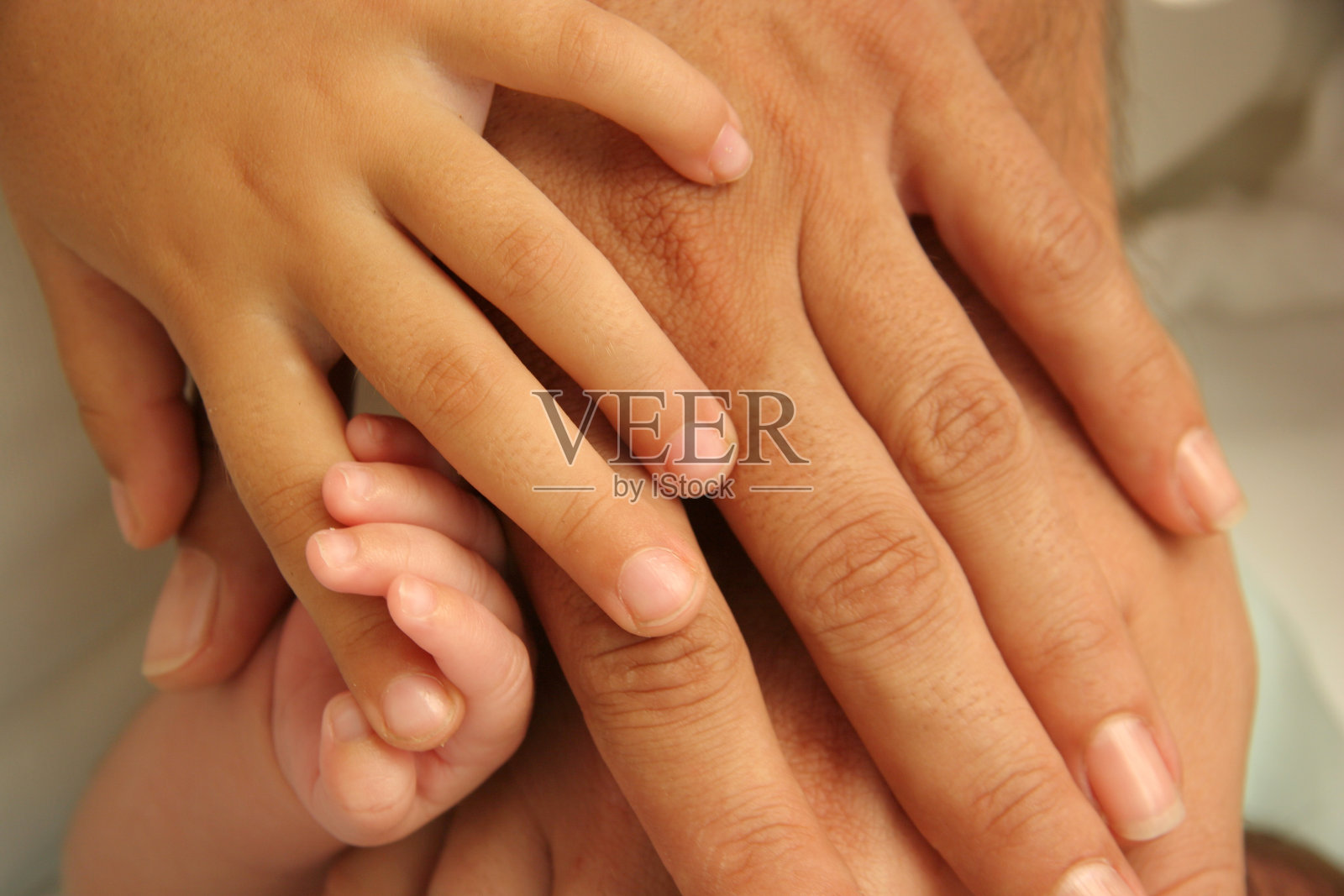 父母、孩子和婴儿的手都紧紧地握在一起照片摄影图片