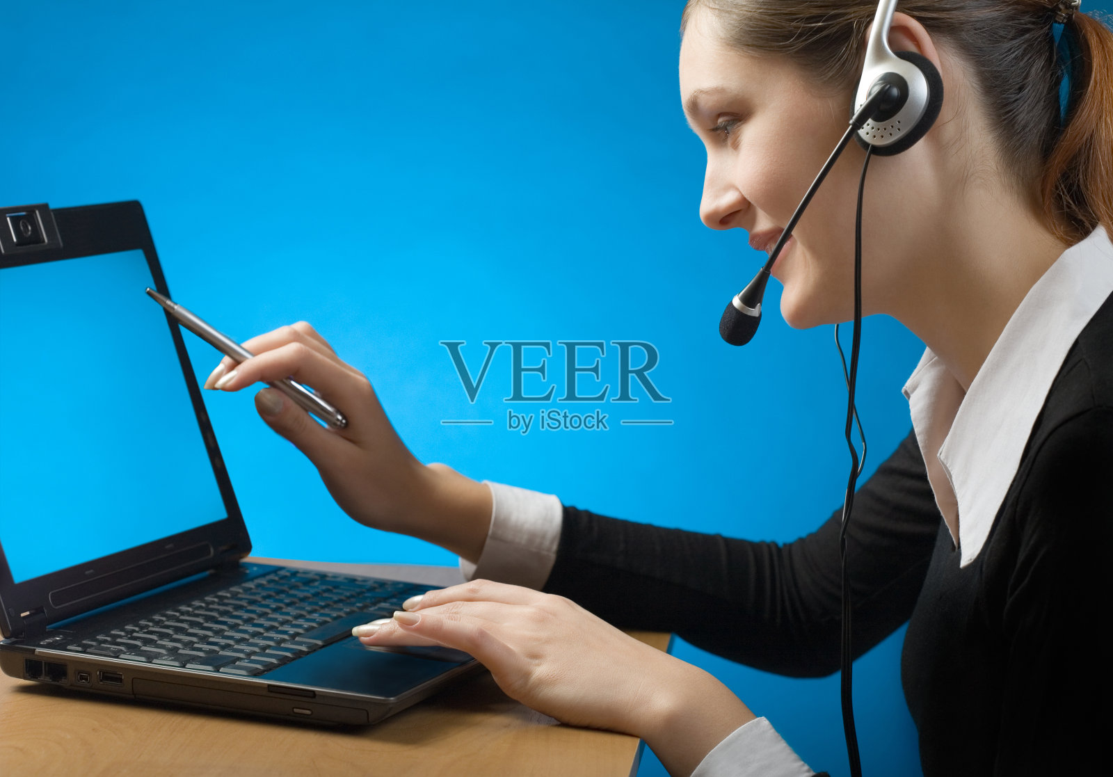 年轻的商务女性或秘书在耳机与笔记本照片摄影图片