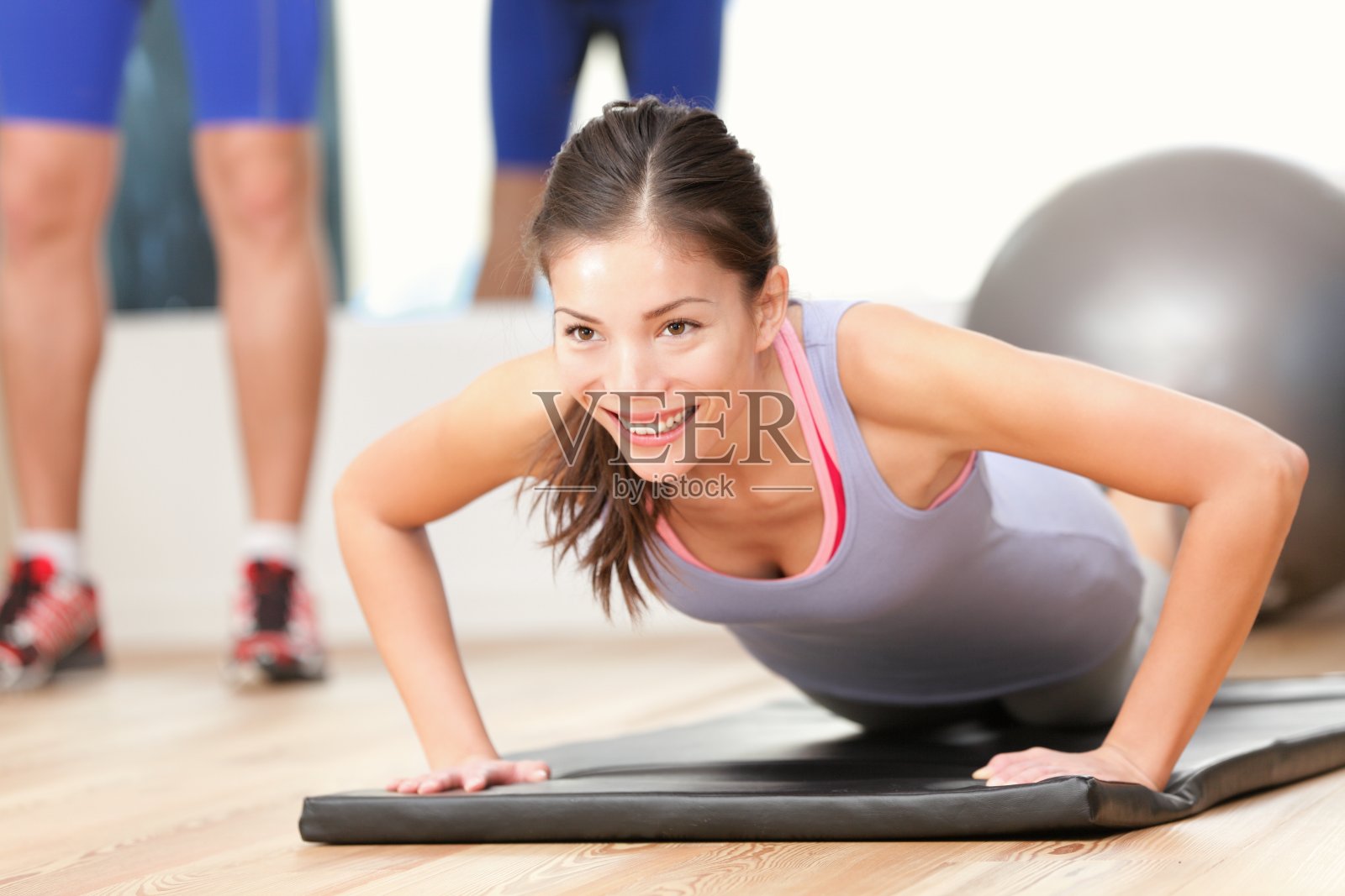 一个女人在体操垫上做俯卧撑照片摄影图片