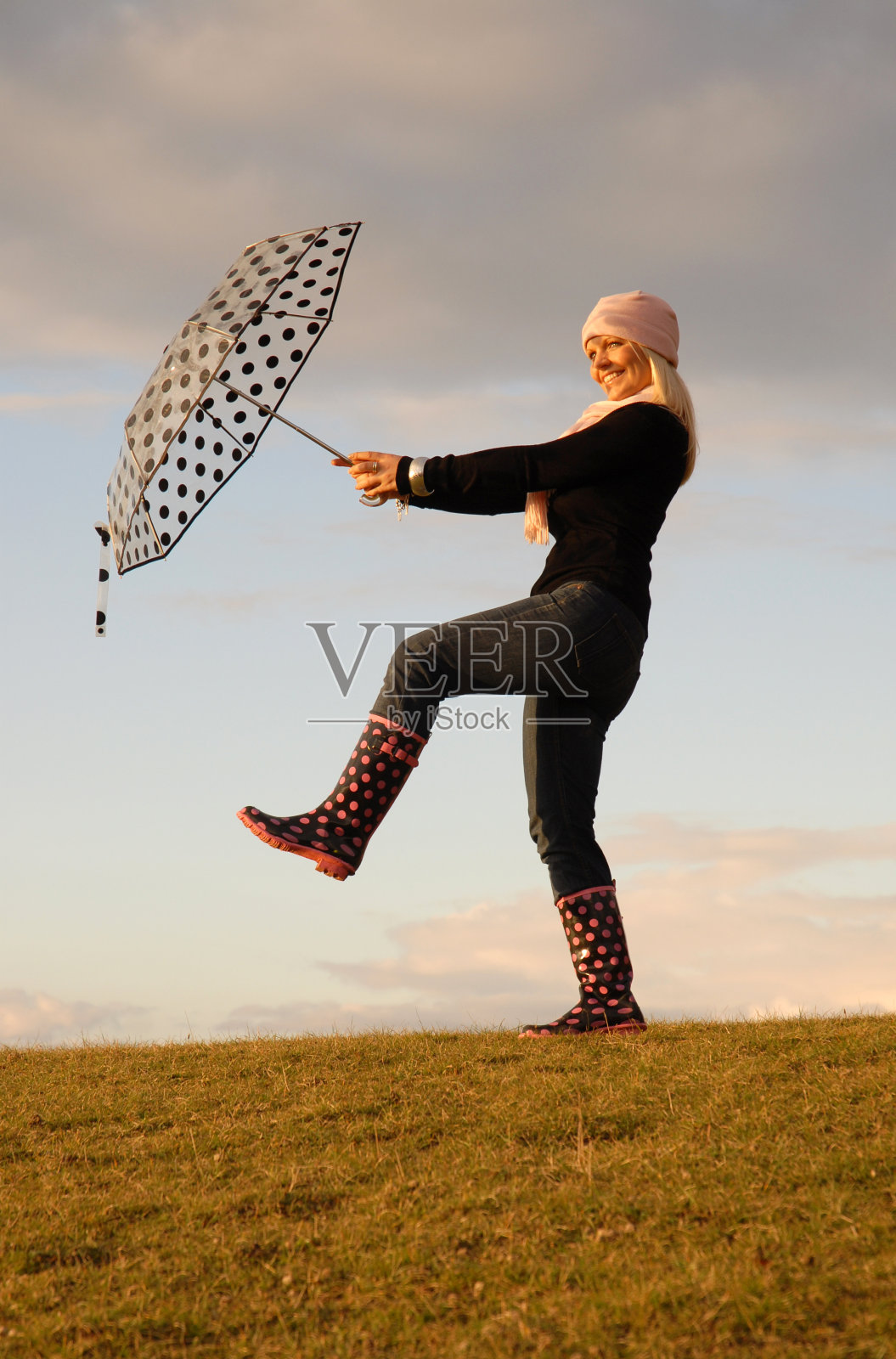拿着伞跳舞的女人。照片摄影图片