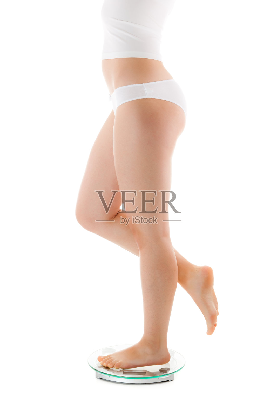 站在浴室磅秤上的苗条女人照片摄影图片