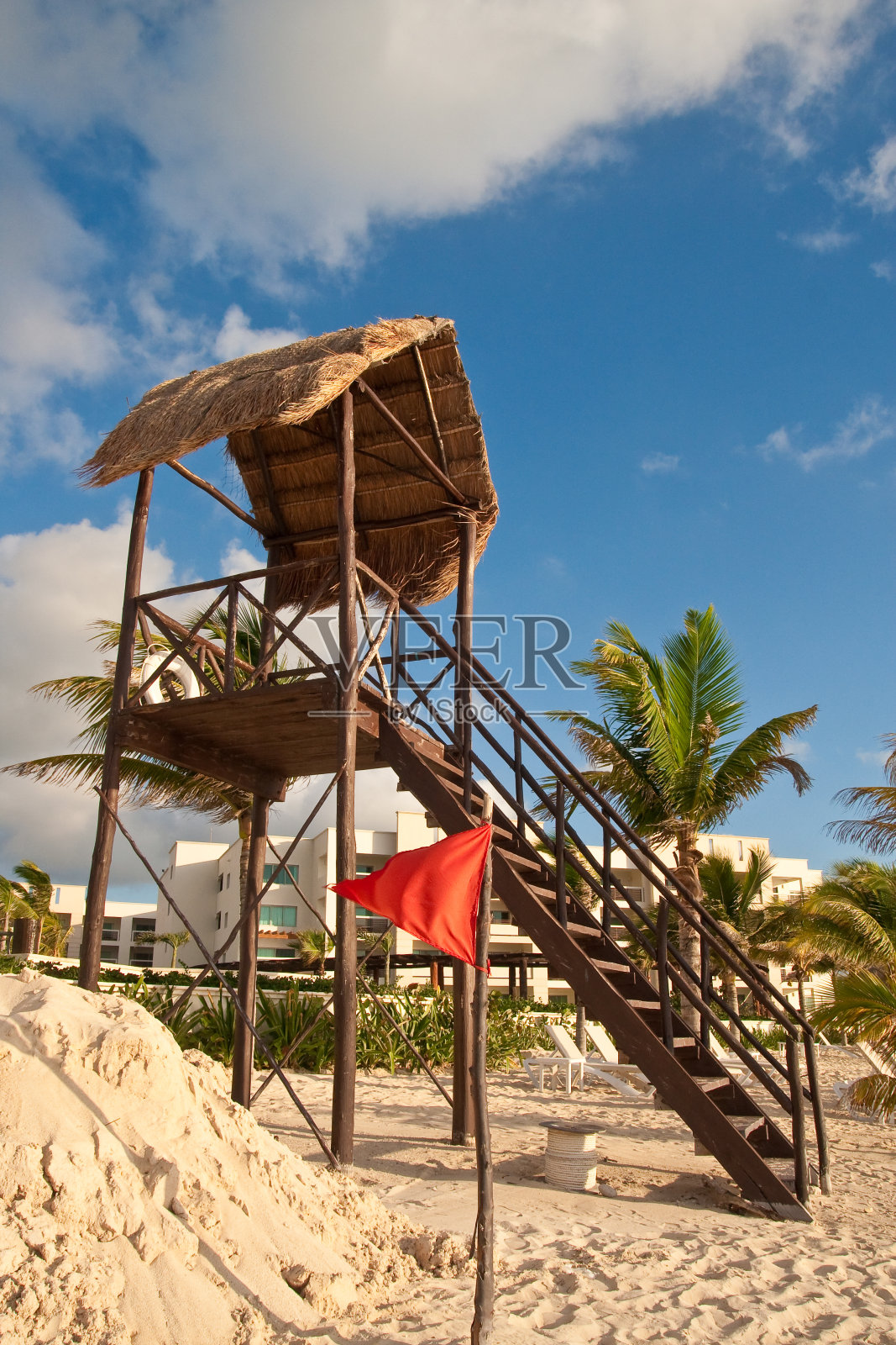 沙堆及救生员站旁悬挂红色警告旗照片摄影图片