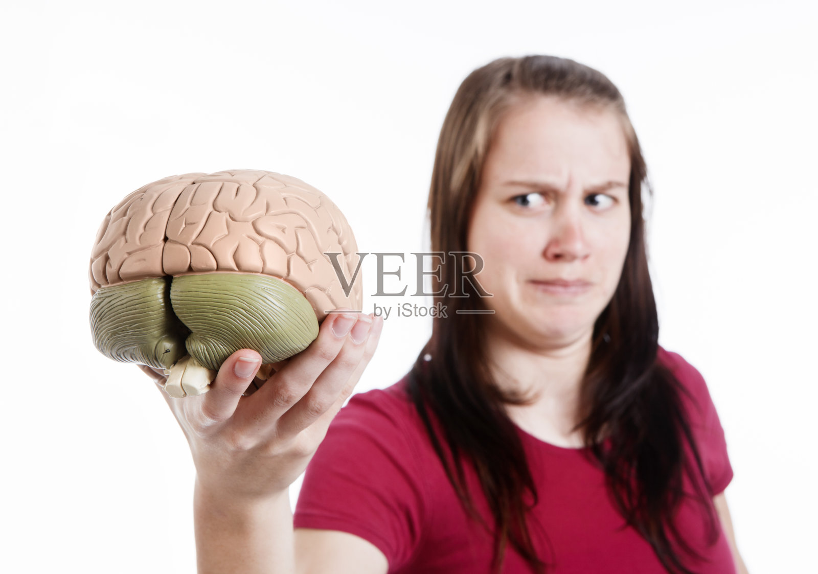 可爱的棕发女人皱着眉头看人类大脑的解剖模型照片摄影图片