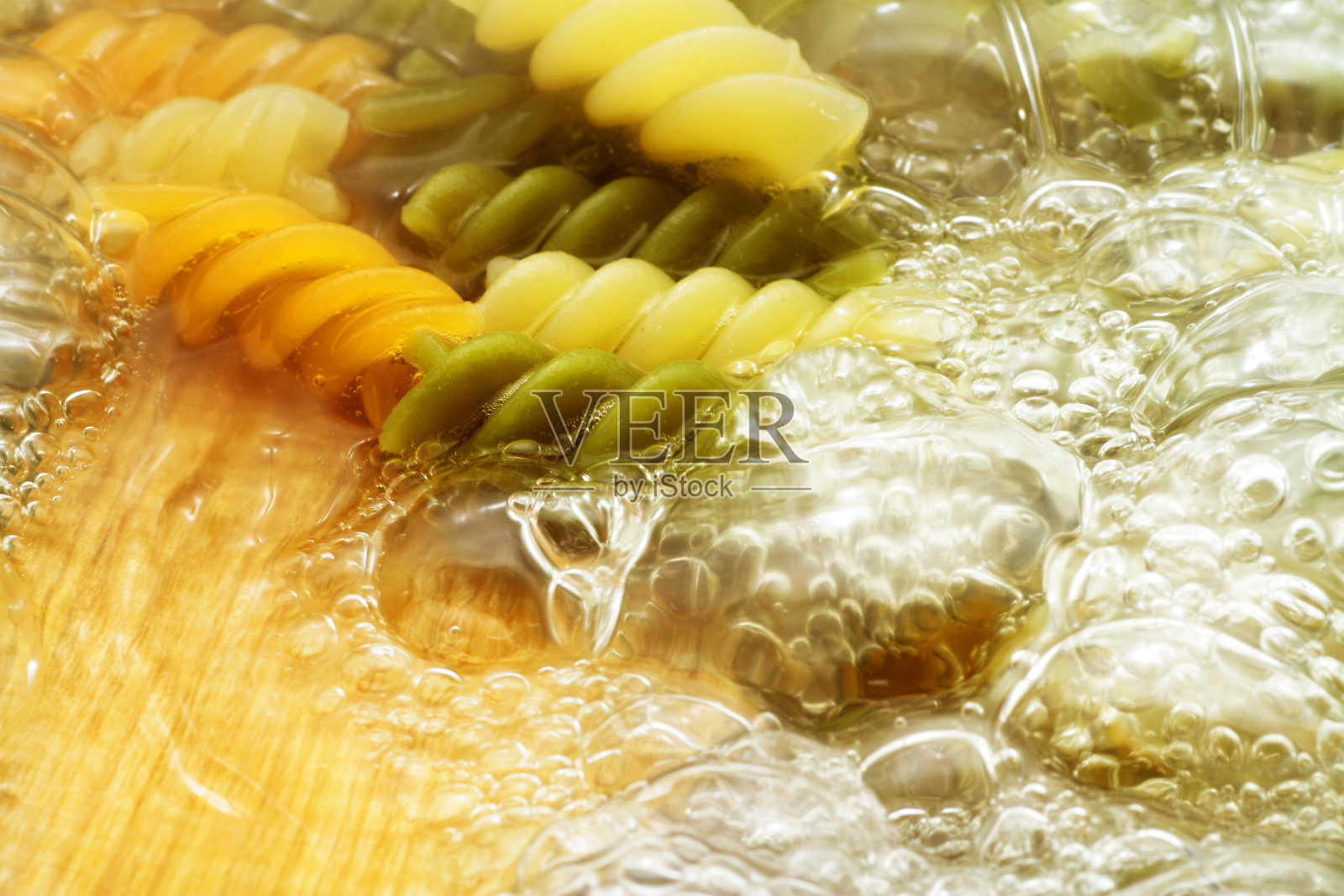 在沸水中放入螺旋形意面照片摄影图片