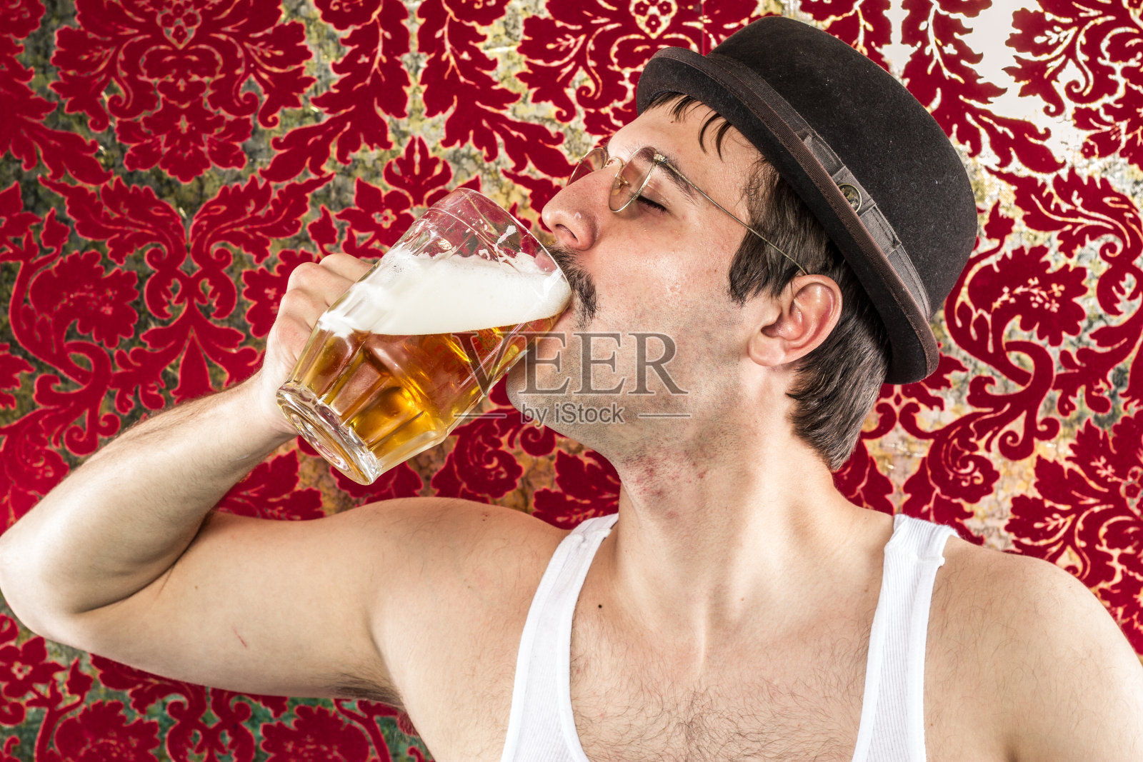 戴着眼镜的黑发白人正在享用大杯啤酒照片摄影图片