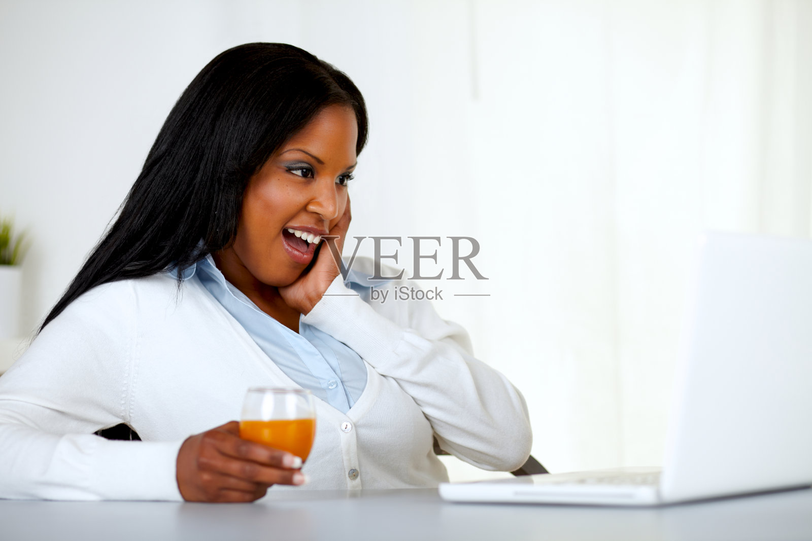 年轻女子惊讶地看着笔记本电脑的屏幕照片摄影图片