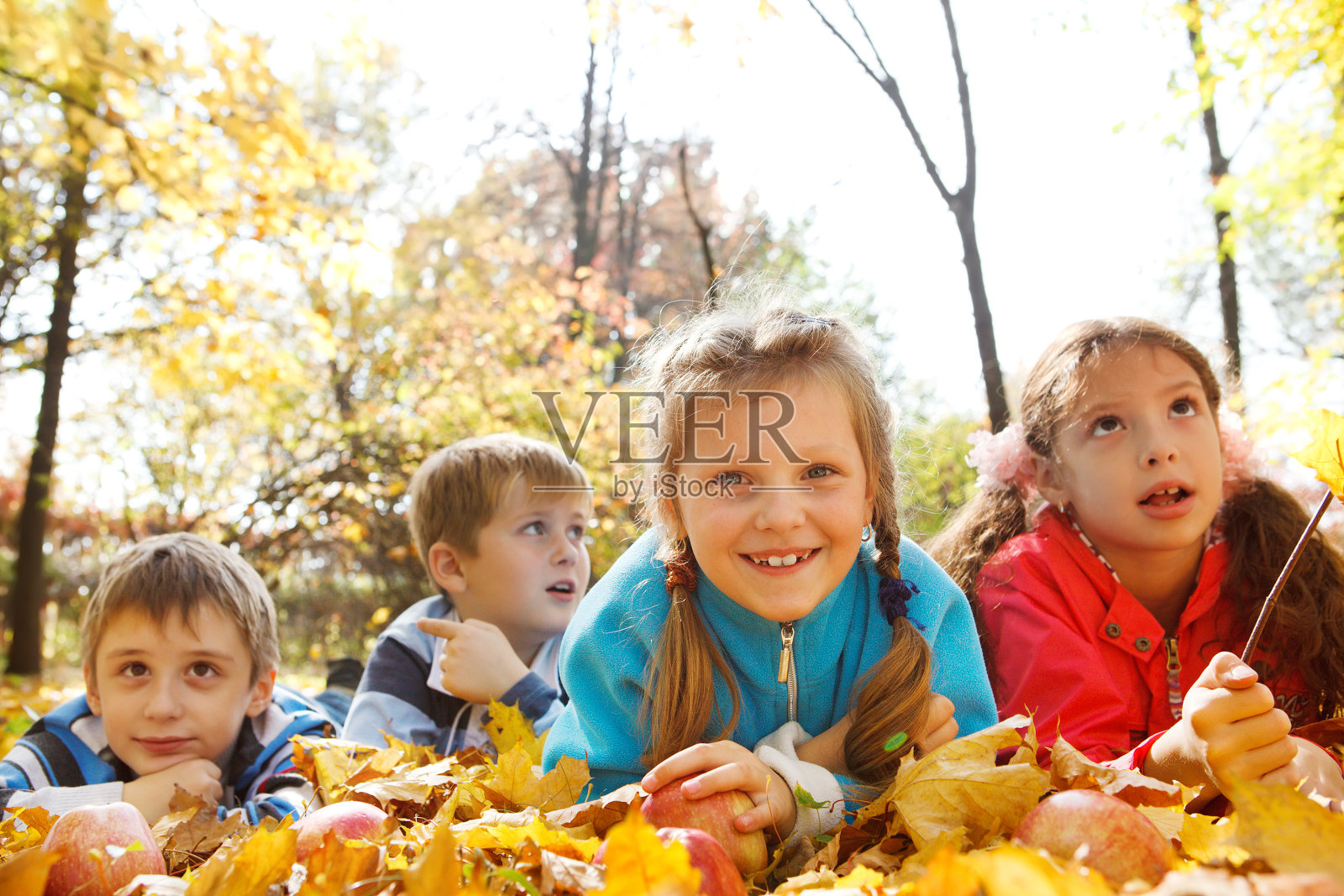 朋友们躺在黄叶上照片摄影图片