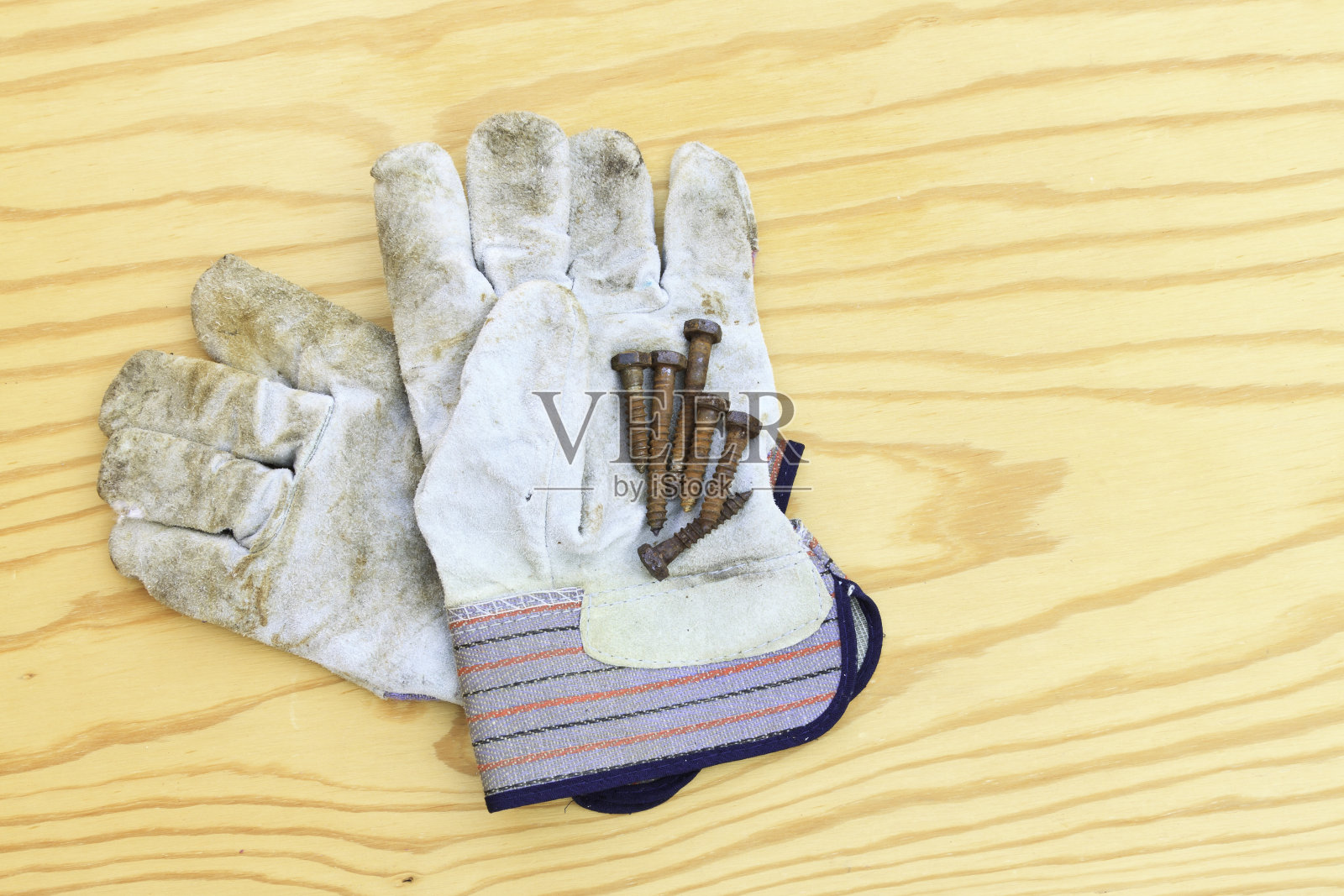 清洁木材上的工作手套和生锈的螺钉照片摄影图片
