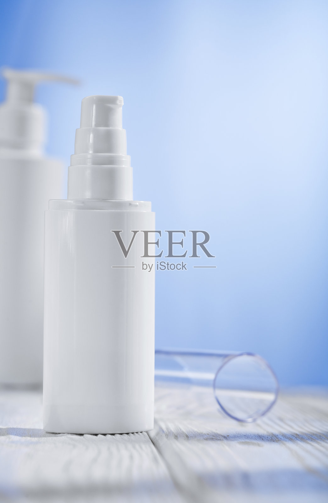 木桌上放两支白色护肤品喷雾照片摄影图片