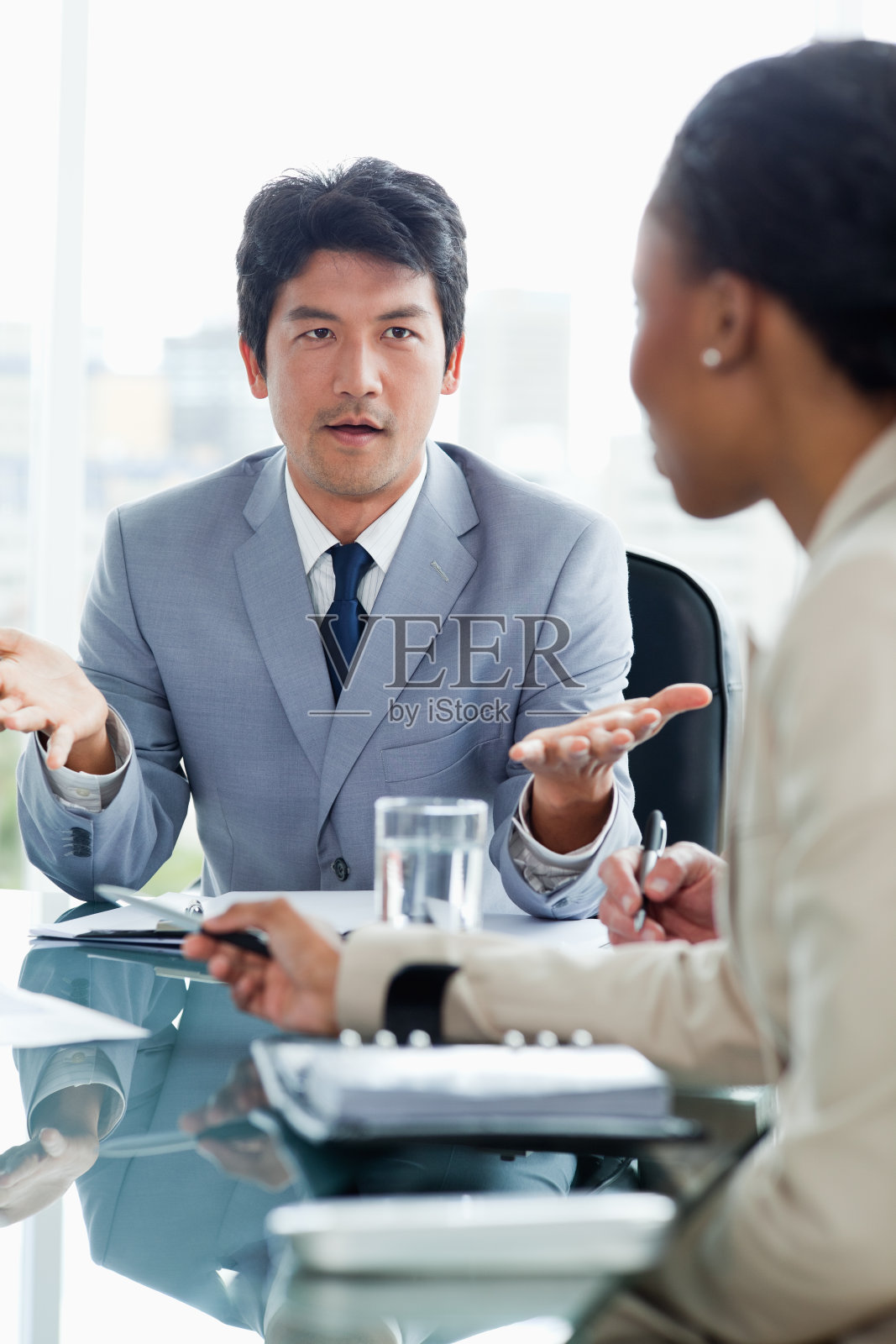 一位严肃的年轻高管正在和他的同事交谈照片摄影图片