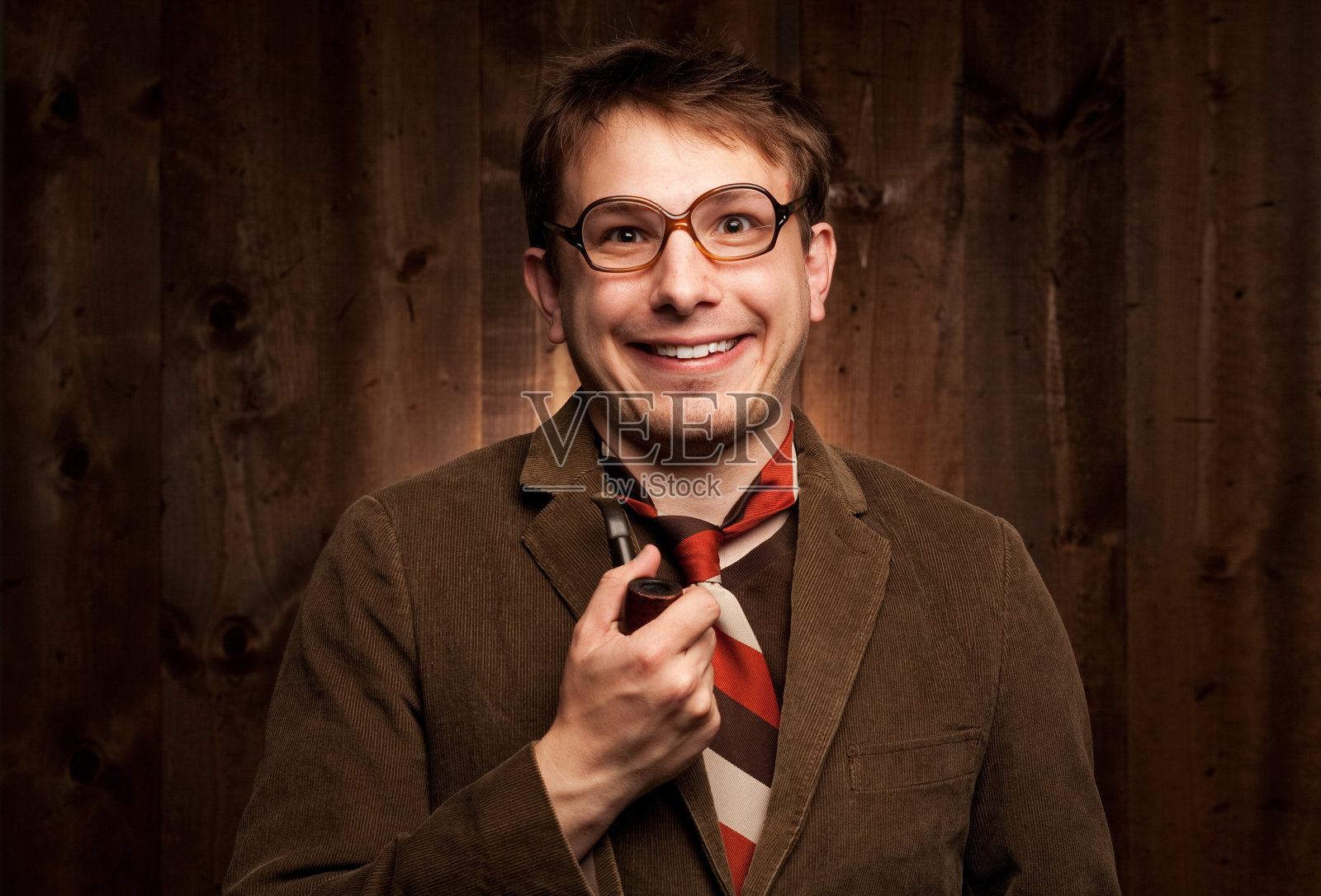 一个穿着棕色衣服对着镜头微笑的书呆子照片摄影图片