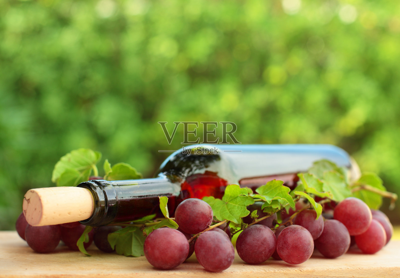 酒瓶，红葡萄，绿叶照片摄影图片
