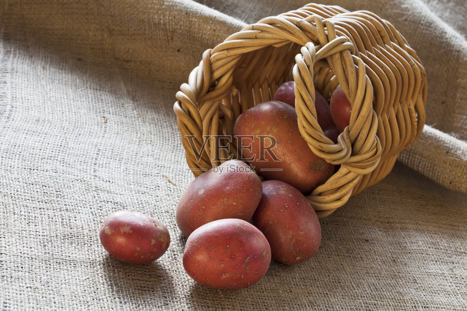 柳条篮子里散落着红土豆照片摄影图片