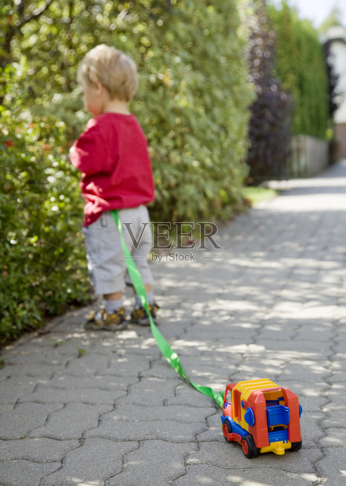 小男孩在公园里玩他的卡车玩具照片摄影图片