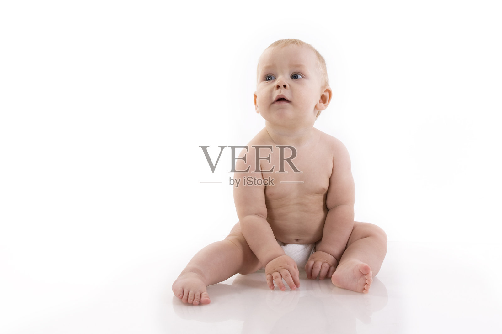 穿着尿布坐在地板上微笑的小男孩照片摄影图片