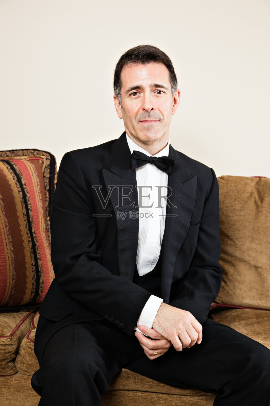 穿着燕尾服坐在沙发上的男人照片摄影图片