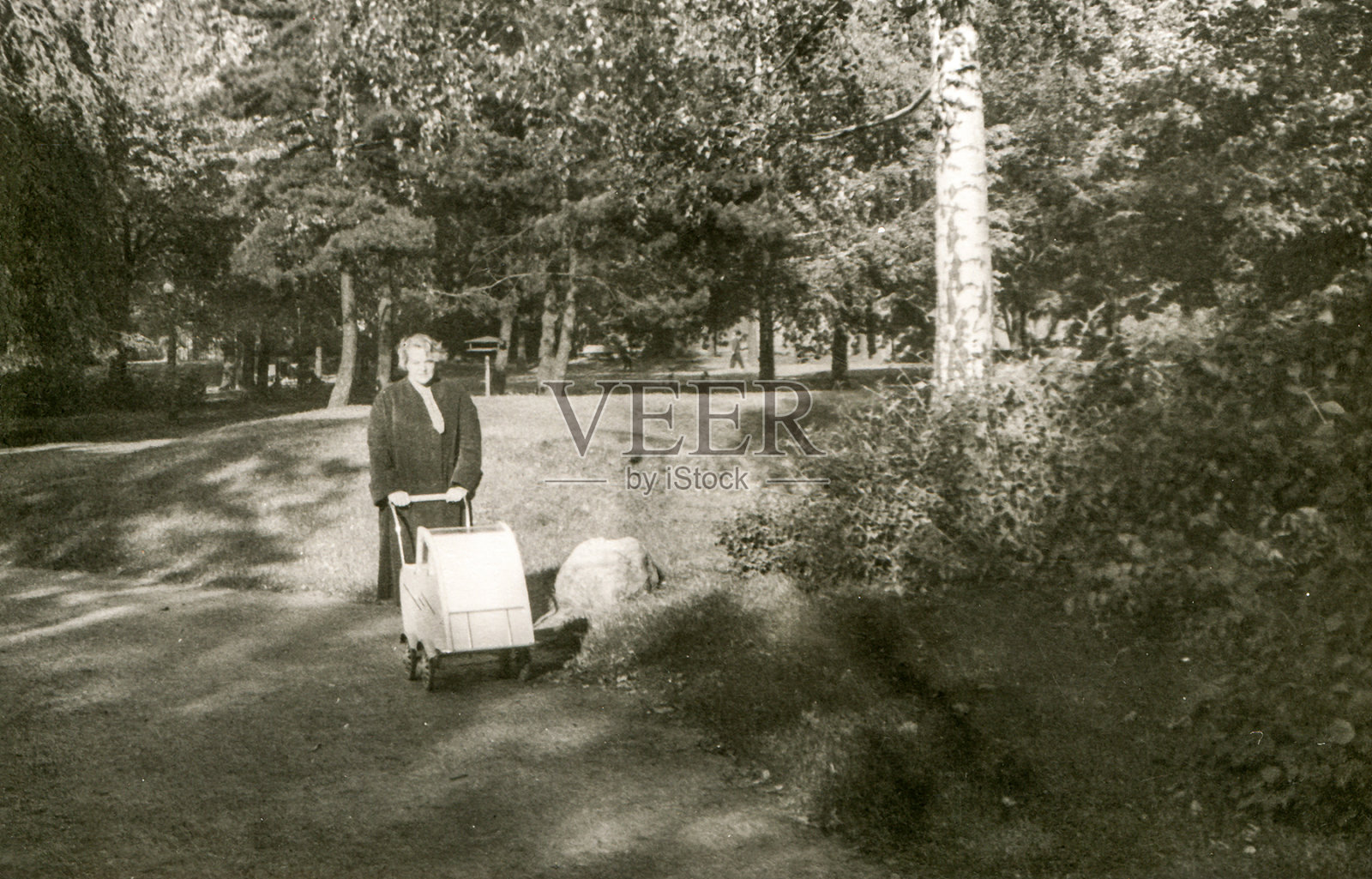 一名妇女推着婴儿车走路的复古照片照片摄影图片