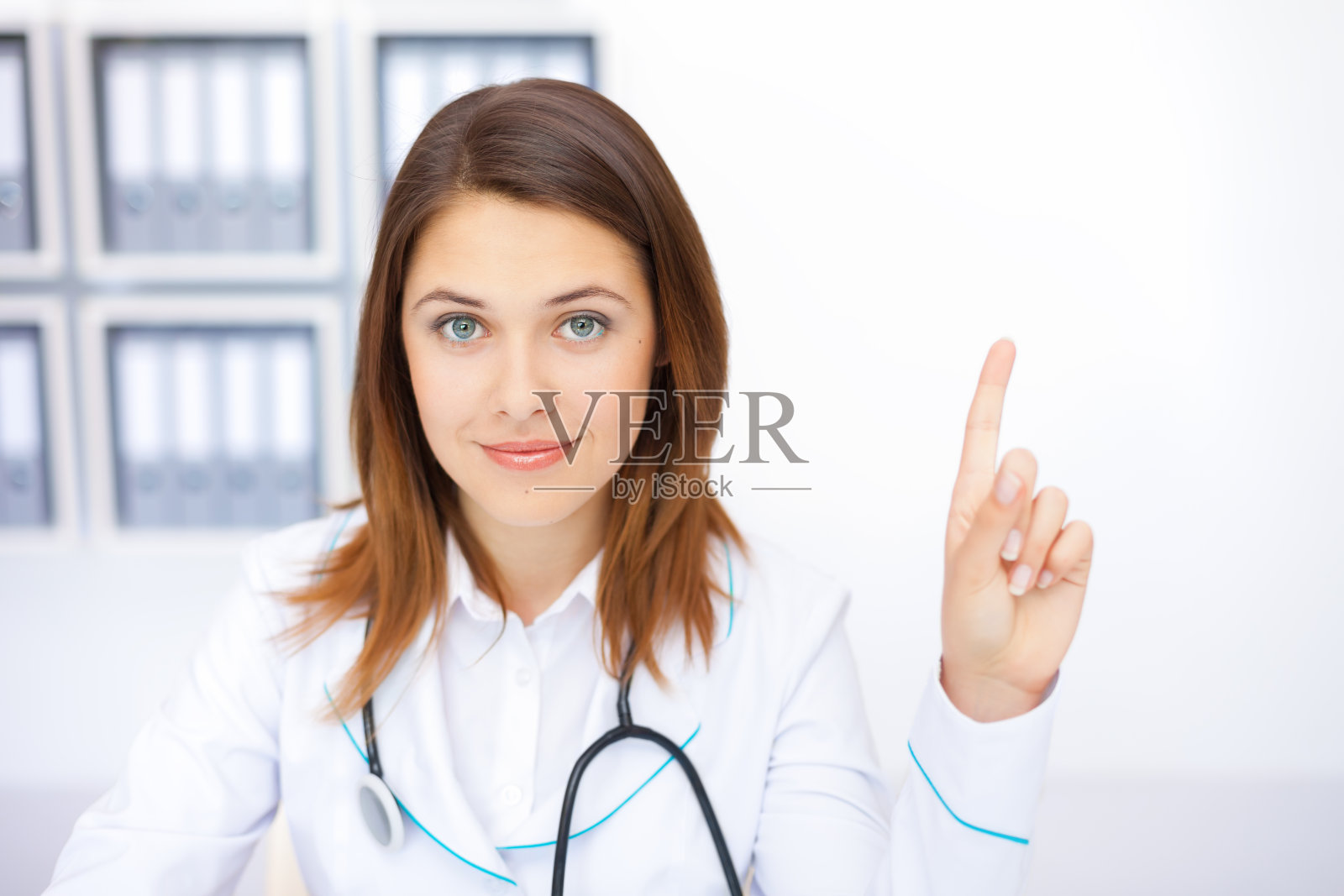 年轻女医生竖着手指的肖像照片摄影图片