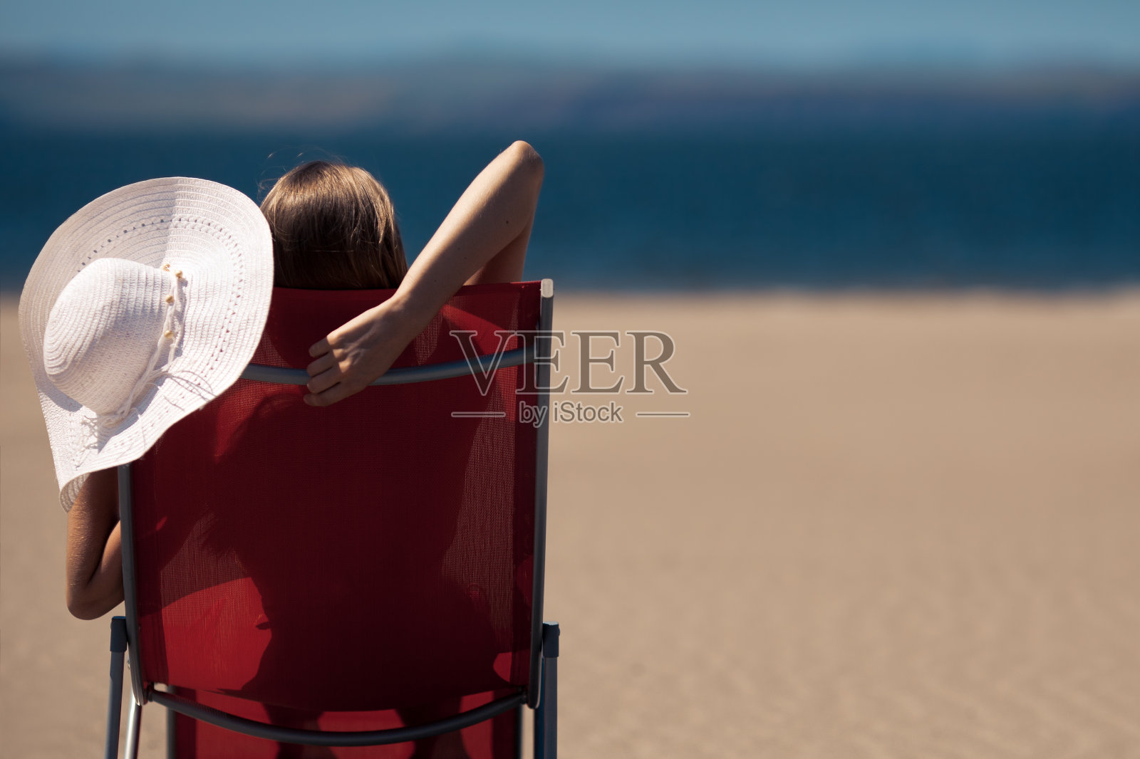 一个女人躺在沙滩上的躺椅上照片摄影图片
