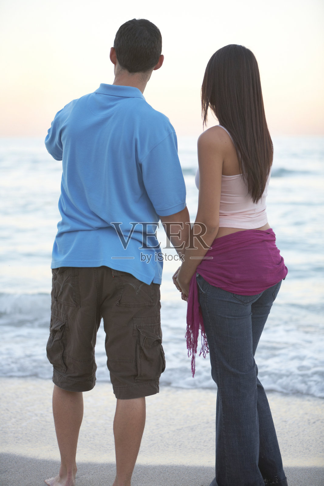 幸福的西班牙夫妇手牵着手在海滩上照片摄影图片