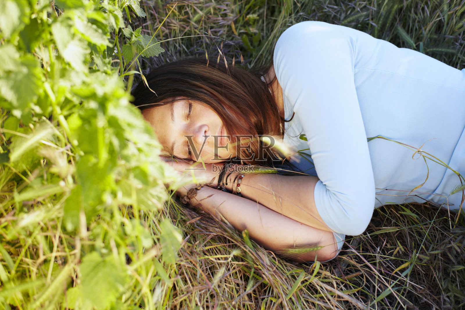 美丽的女孩躺在草地上。照片摄影图片