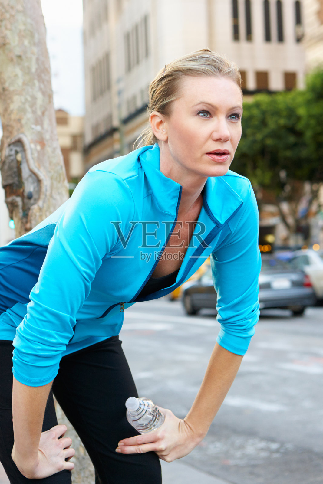 在街上跑步时休息的女人照片摄影图片