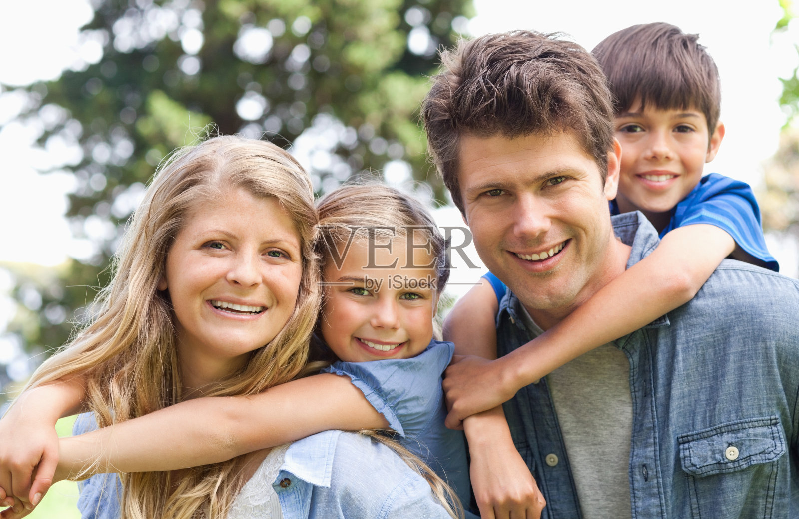 父母抱着孩子微笑的家庭特写照片摄影图片