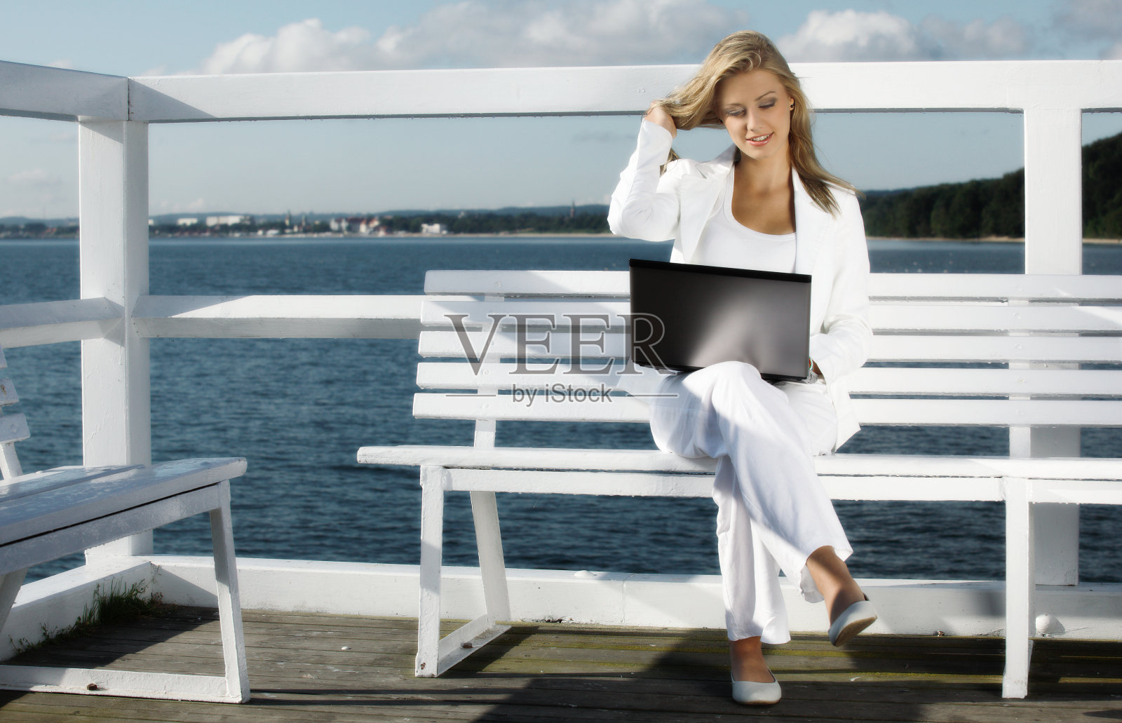微笑的女人在户外使用笔记本电脑照片摄影图片