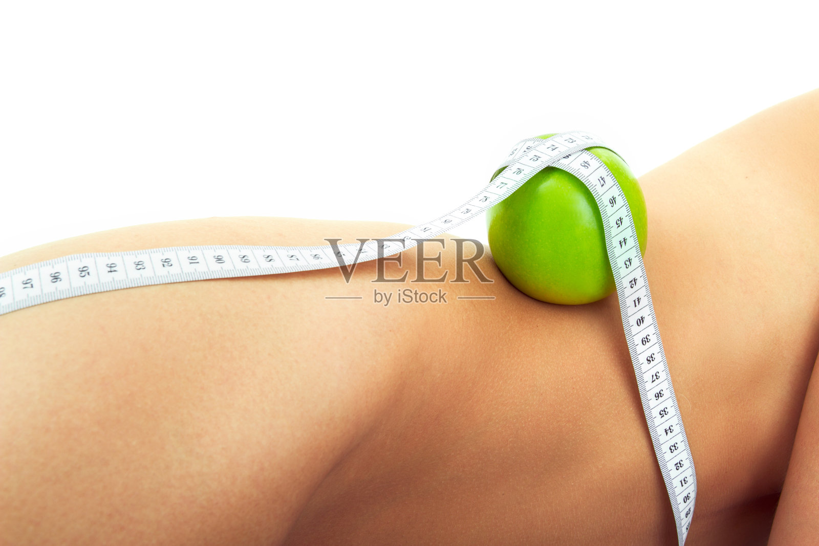 苹果用卷尺绑在女人身上照片摄影图片
