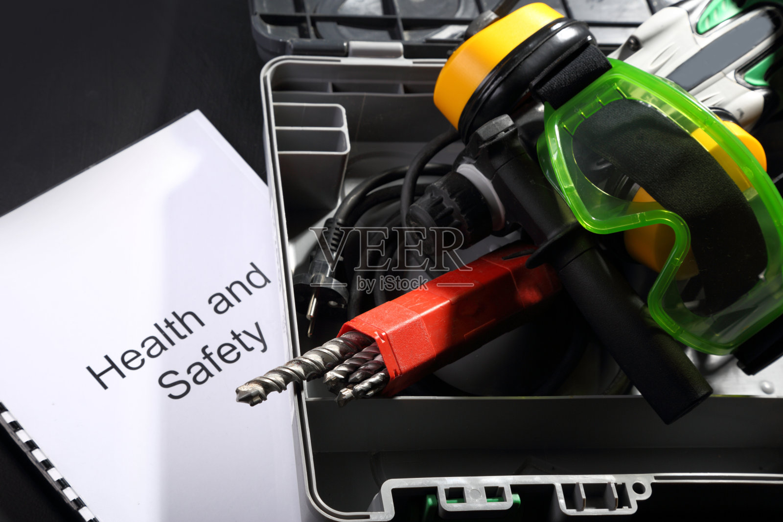 带有钻头、耳机和护目镜的穿孔器照片摄影图片